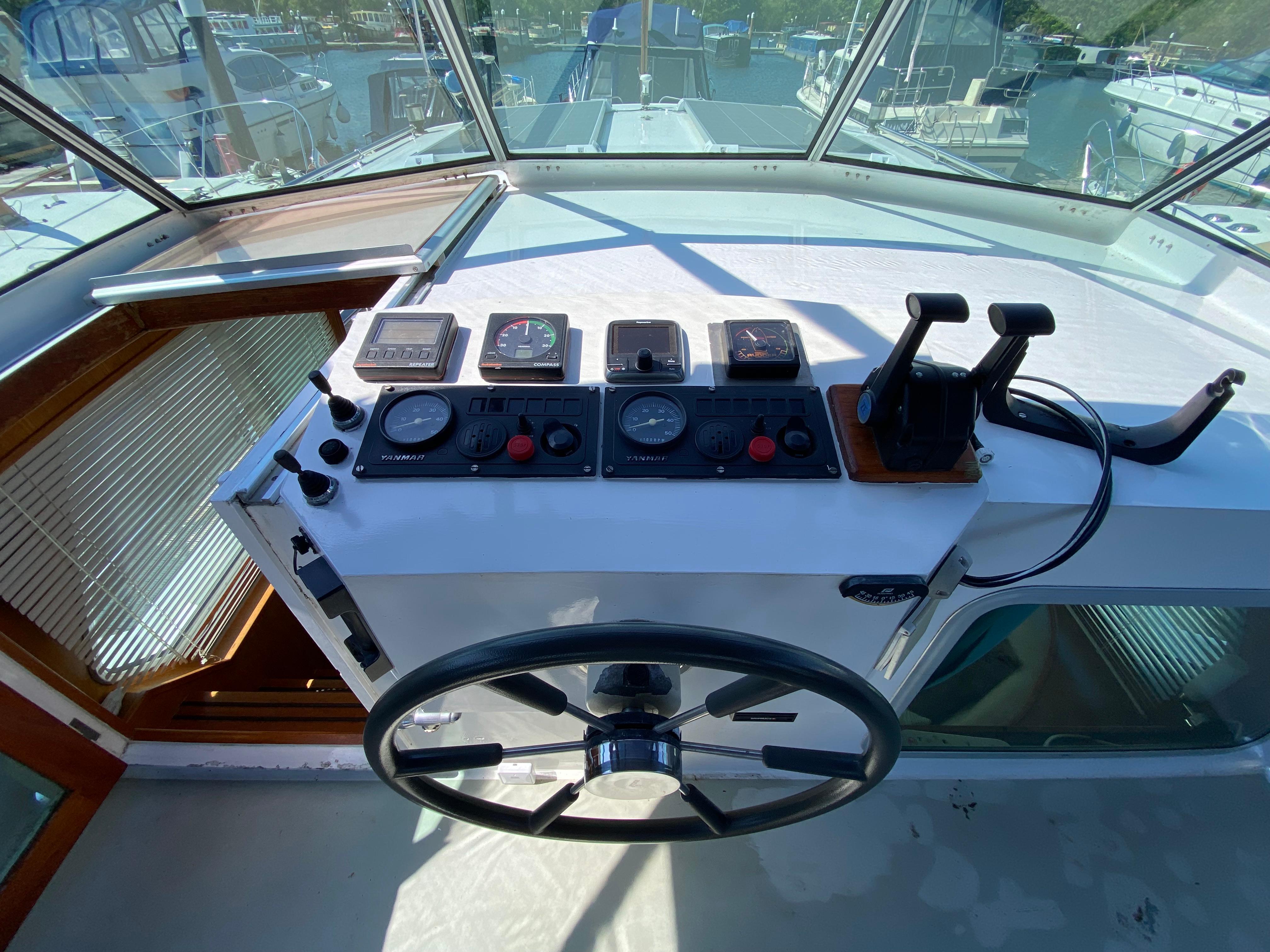 Helm of 1993 Aquanaut Beauty 1200 AK with navigation instruments and dual throttle controls.