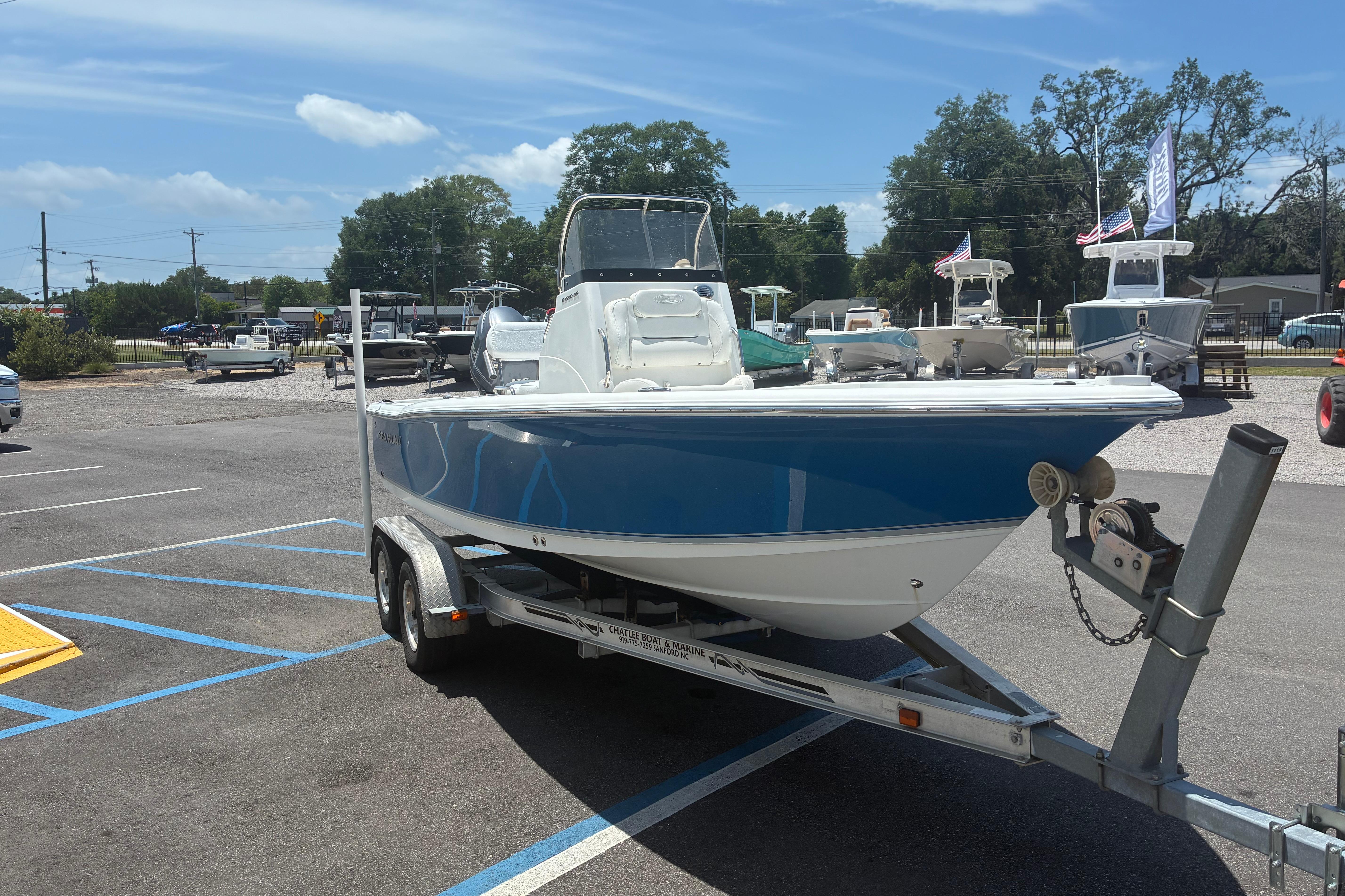 2014 Sea Hunt BX 20 BR boat on trailer in parking lot under clear sky.
