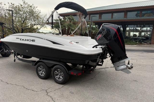 2026 Tahoe 1950 boat on trailer with powerful outboard motor, parked outdoors.