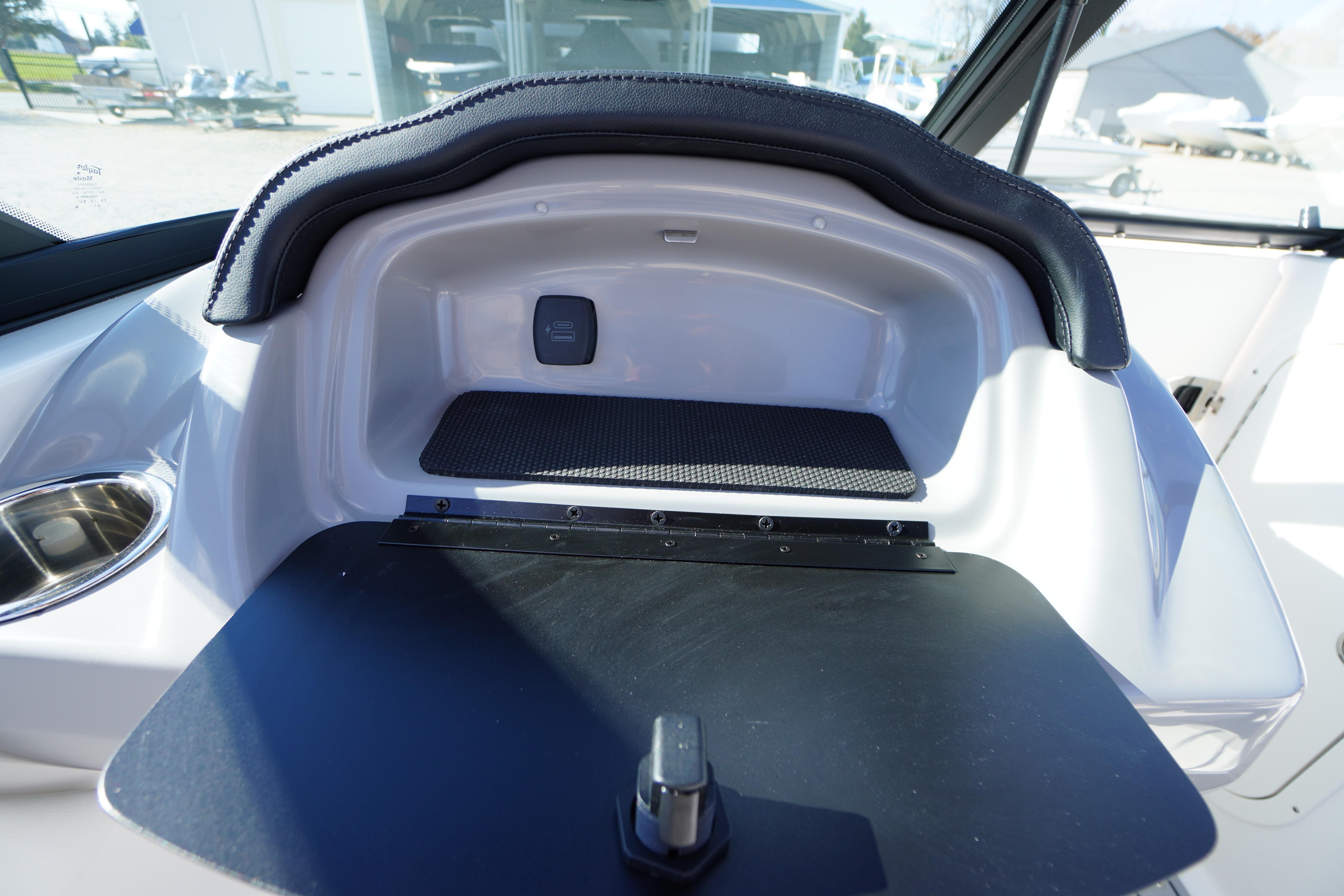 2026 Chaparral 23 SSi OB boat interior storage compartment with cup holder.