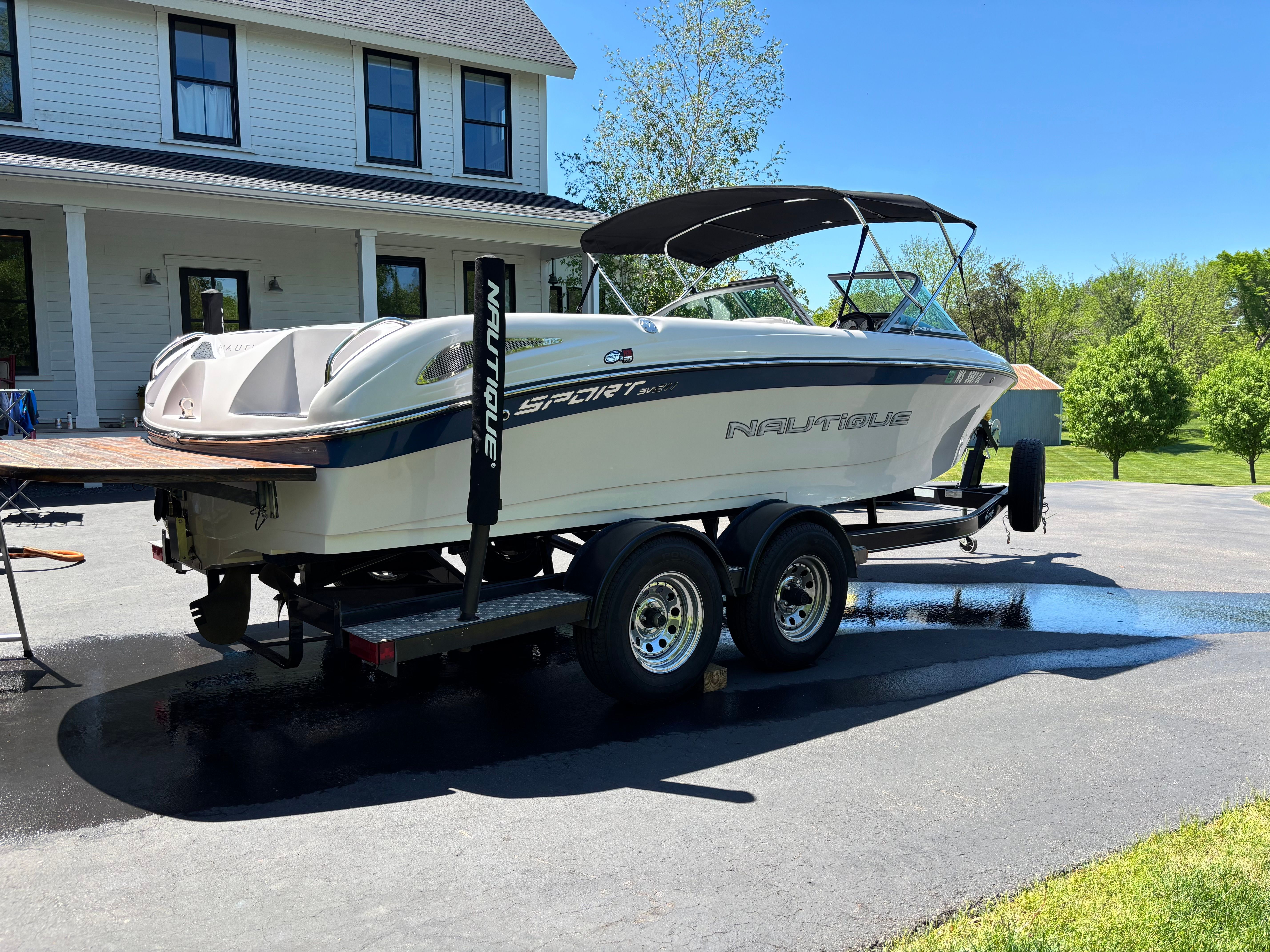 2005 Nautique Sport SV-211 boat on trailer in front of house.