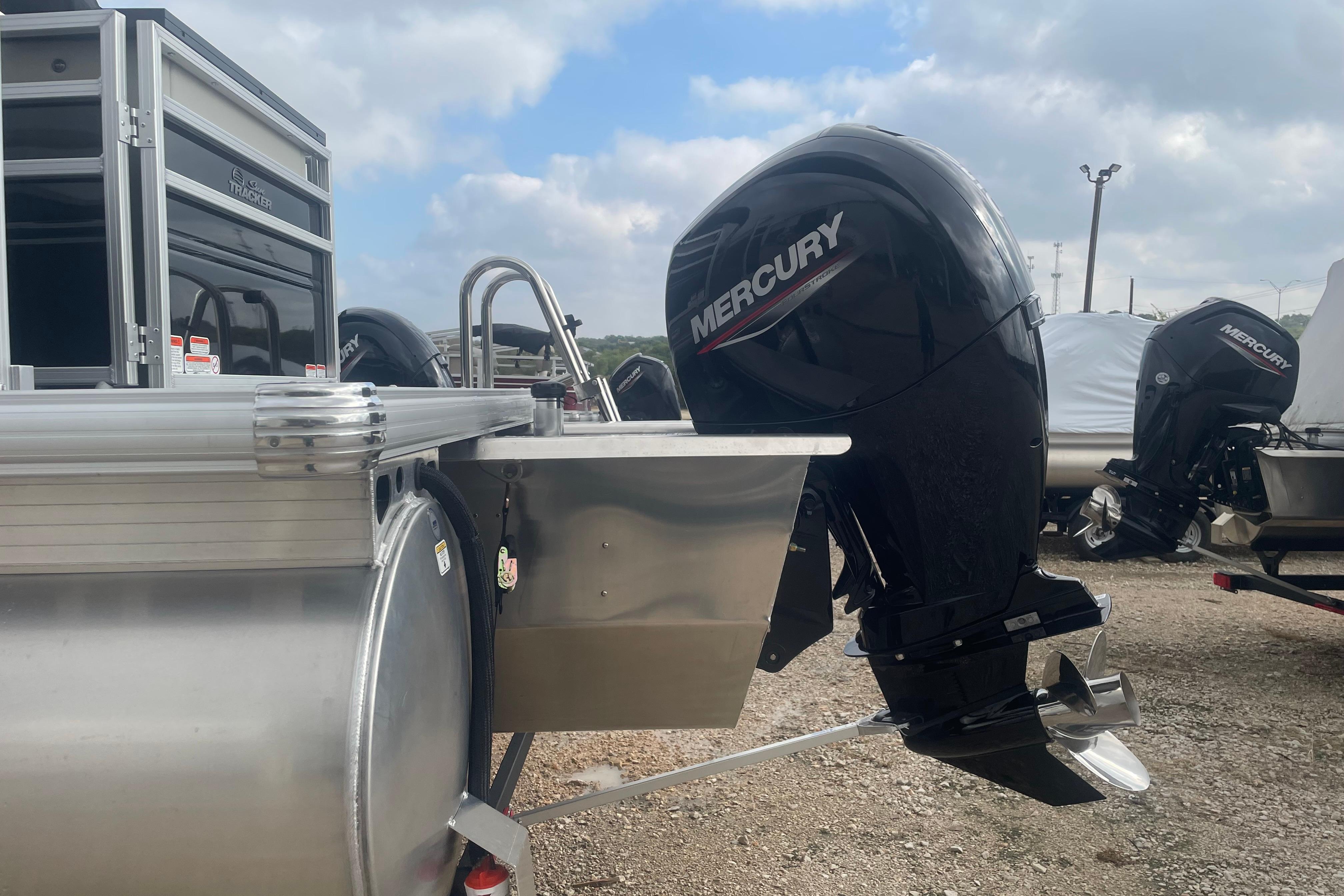 2026 Sun Tracker Fishin' Barge 22 XP3 with Mercury outboard motor, parked outdoors.