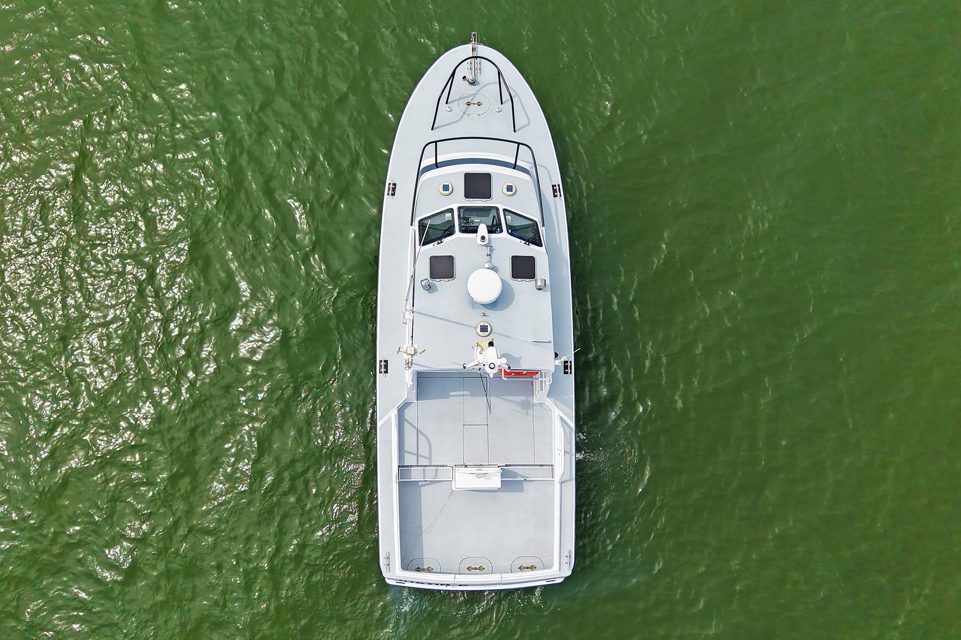 Aerial view of 1990 Boston Whaler 36 Defiance boat on green water.