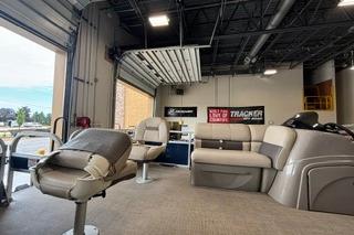 2022 Sun Tracker Fishin' Barge 22 DLX interior with seating in a showroom.