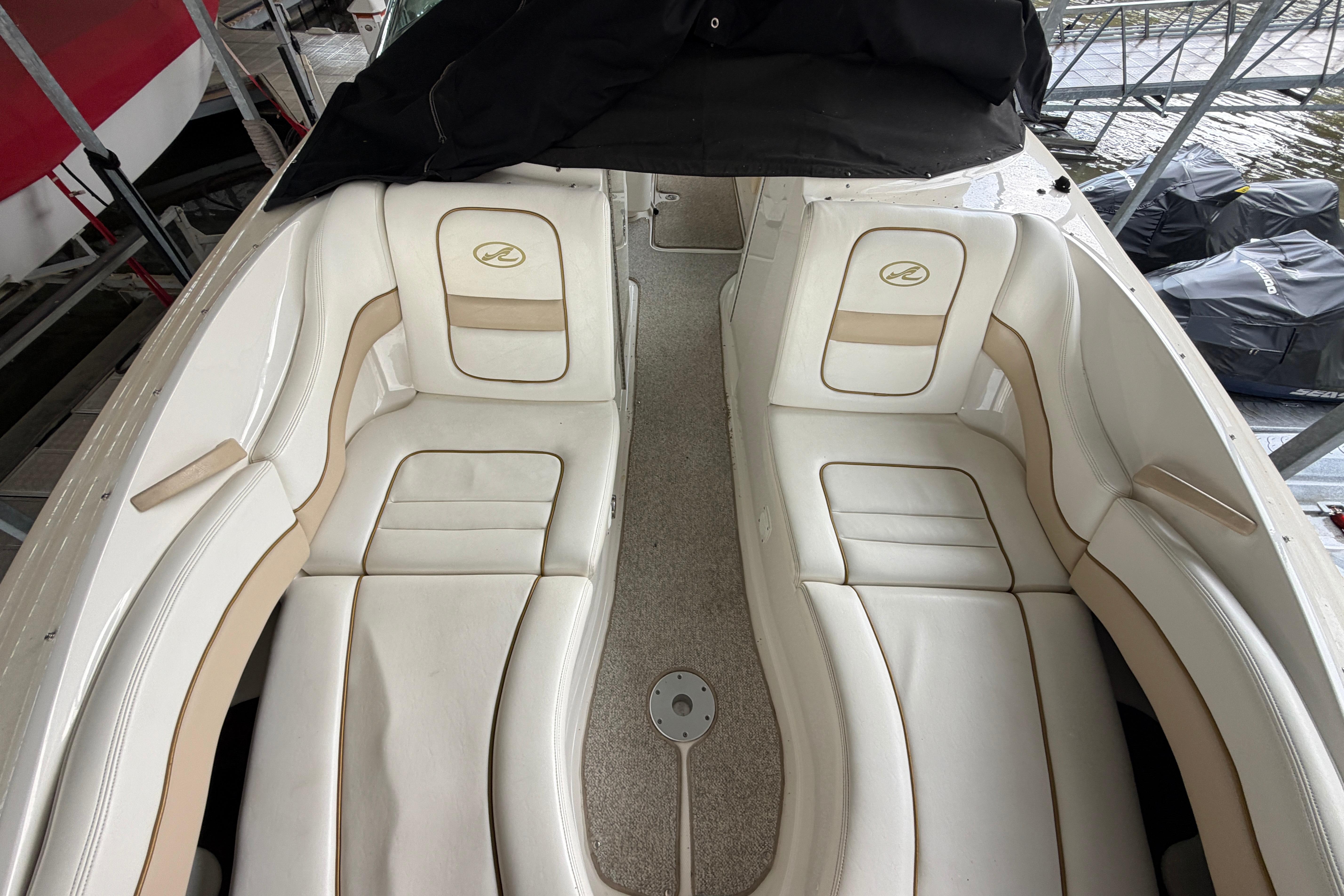 2003 Sea Ray 290 Bowrider with white leather seating, docked in a marina.