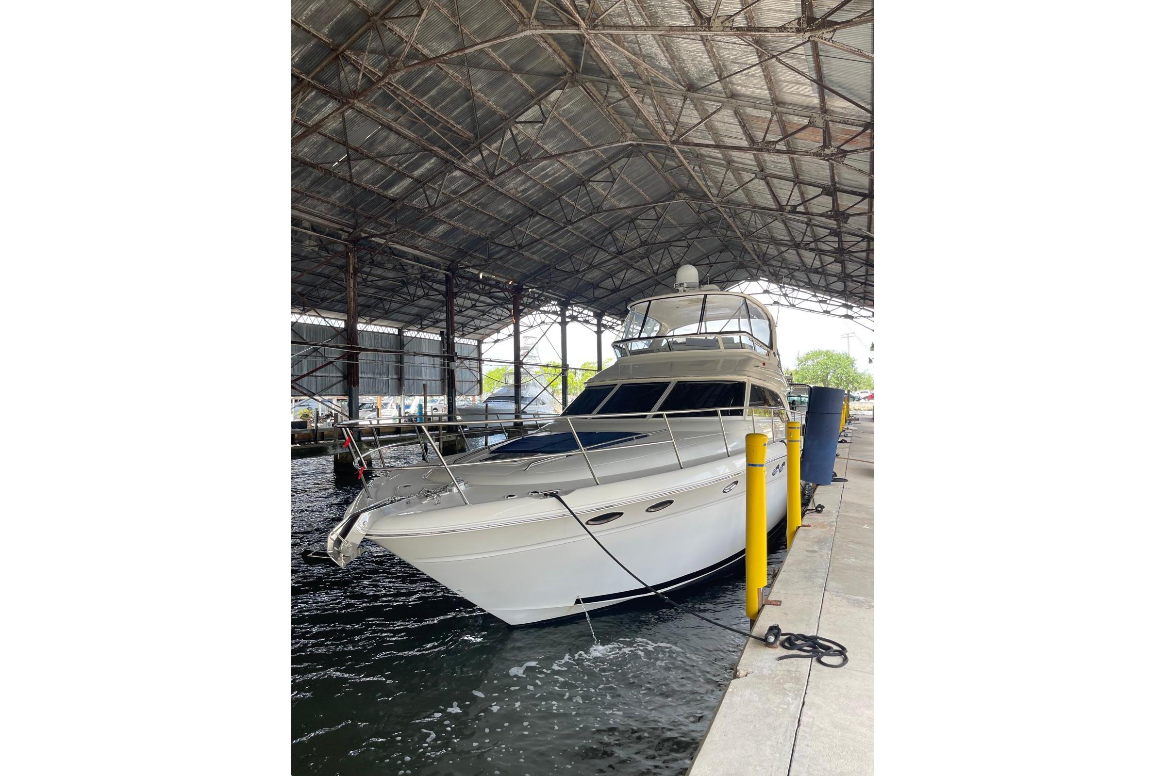 2004 Sea Ray 480 Sedan Bridge yacht docked under a covered marina.