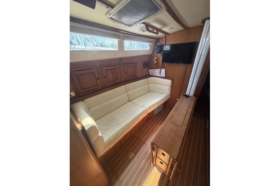 Interior of 2002 Saga 43 yacht with cozy seating and wooden cabinetry.
