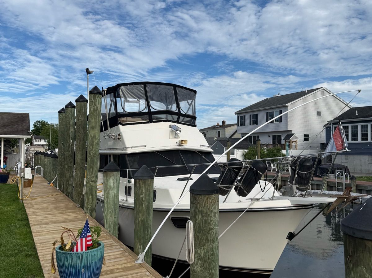 1982 Carver 36 Aft Cabin Motor Yacht docked with houses in the background.