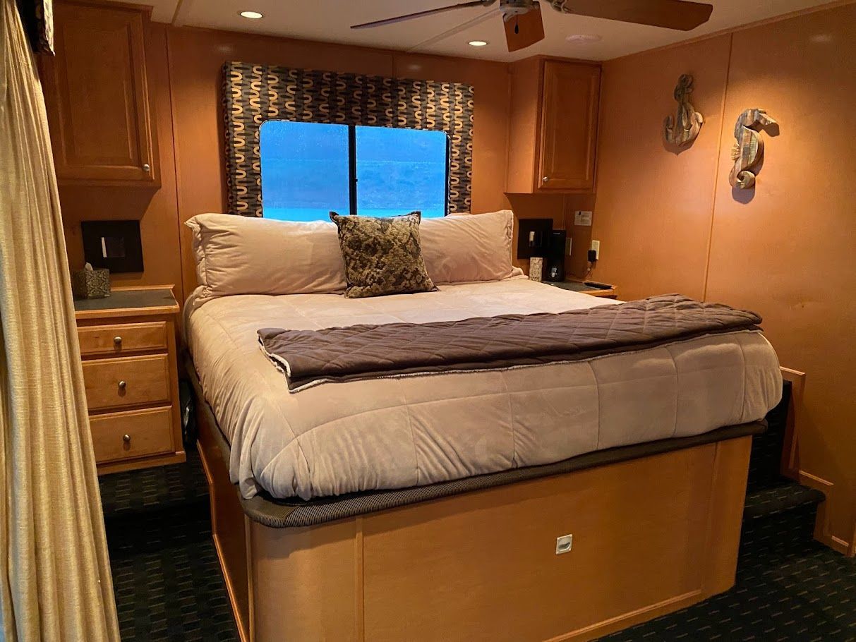 Bedroom in Summersun Houseboat 16x68, 2006 model, featuring cozy bed and wooden furnishings.
