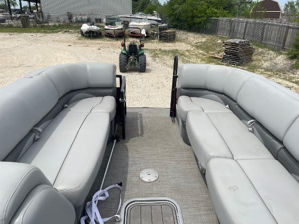 2023 Regency 250DL3 pontoon boat interior with gray seating, parked outdoors.