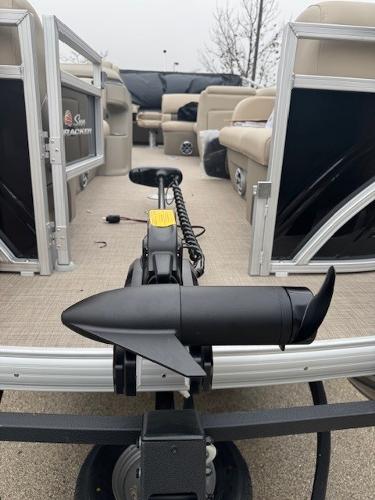2025 Sun Tracker SportFish 22 DLX pontoon boat with trolling motor, beige seating, and spacious deck.
