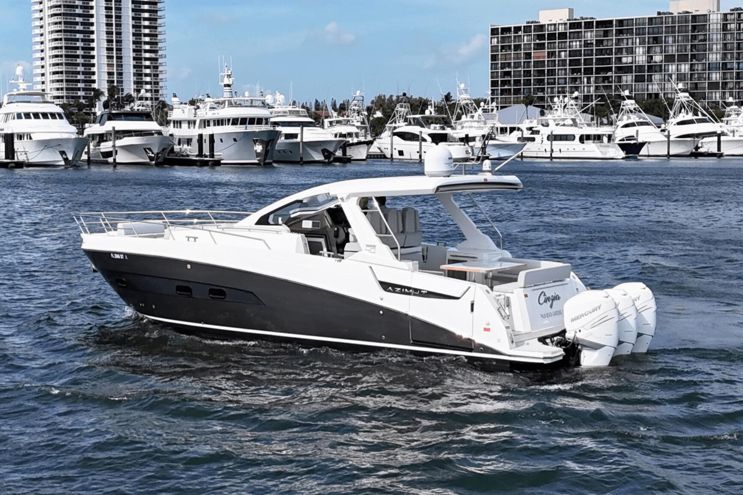 Azimut 40 Verve 2020 yacht cruising in a marina with luxury boats in the background.