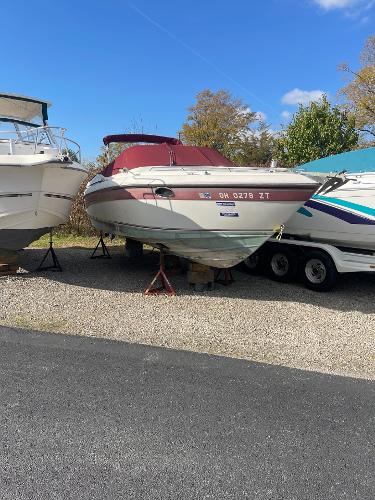 1992 Regal Ventura boat on trailer, parked outdoors under clear blue sky.