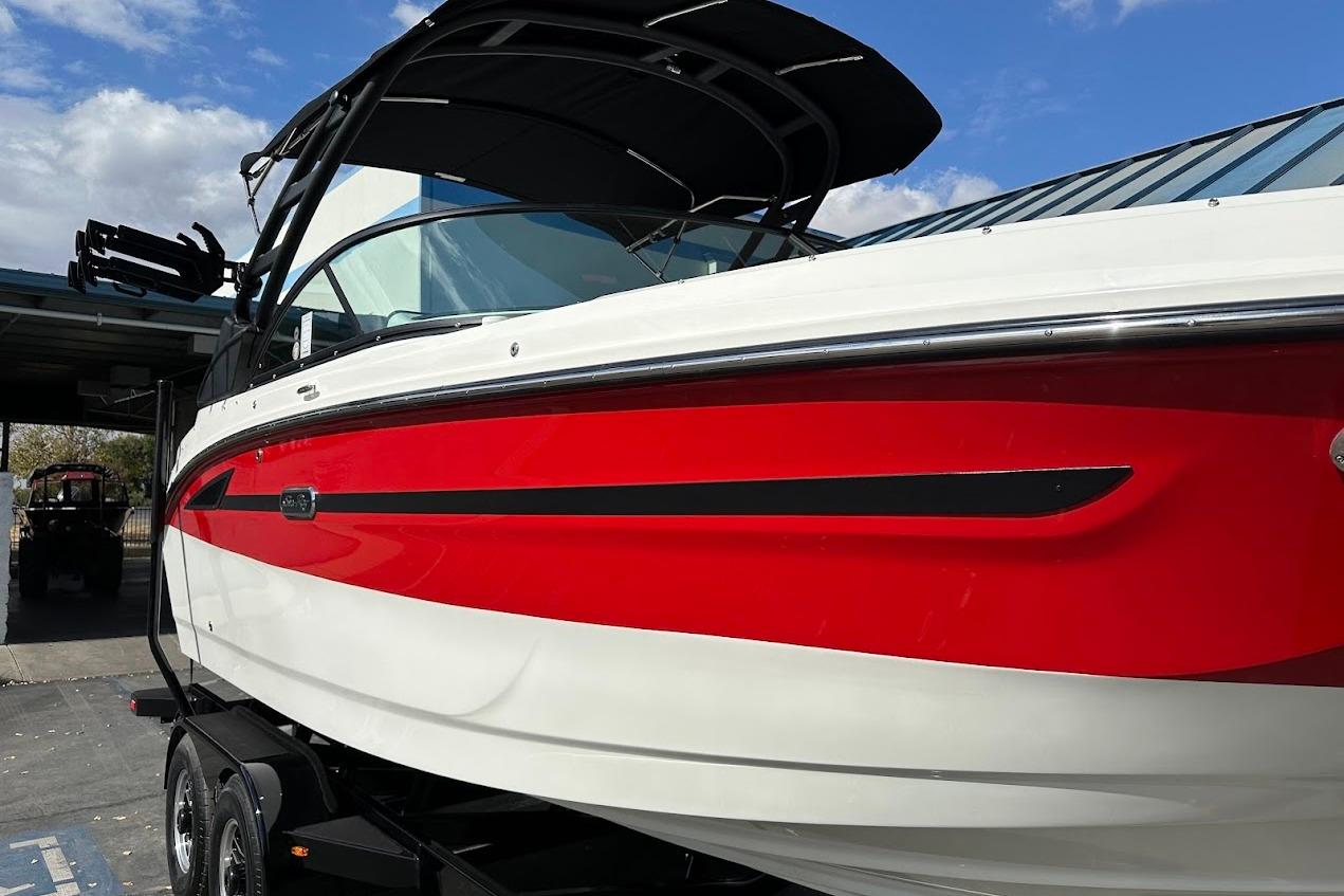 2026 Sea Ray SDX 230 Surf boat with red and white exterior, parked on a trailer.