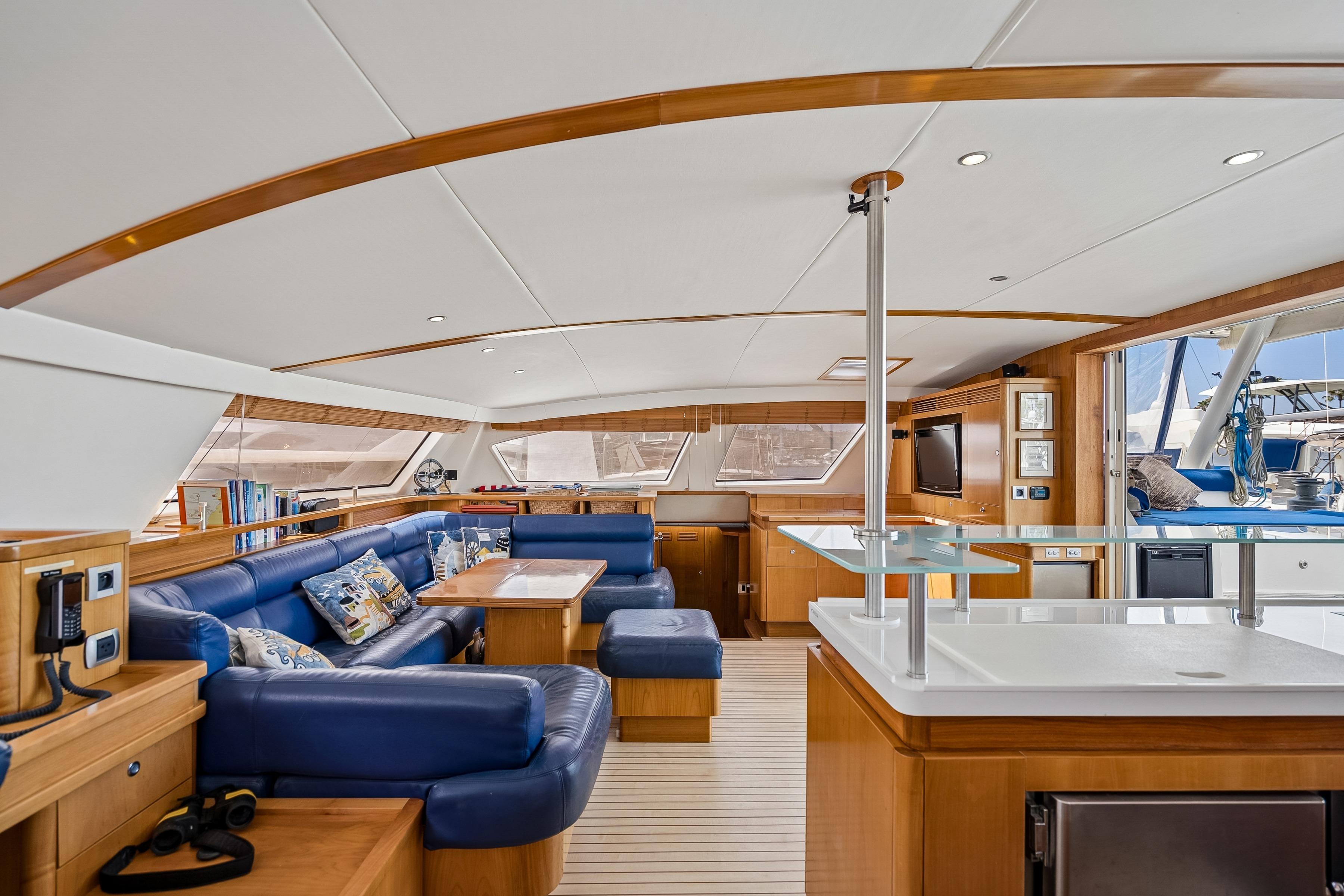 Luxurious interior of 2009 Catana 65 yacht with blue seating and modern amenities.