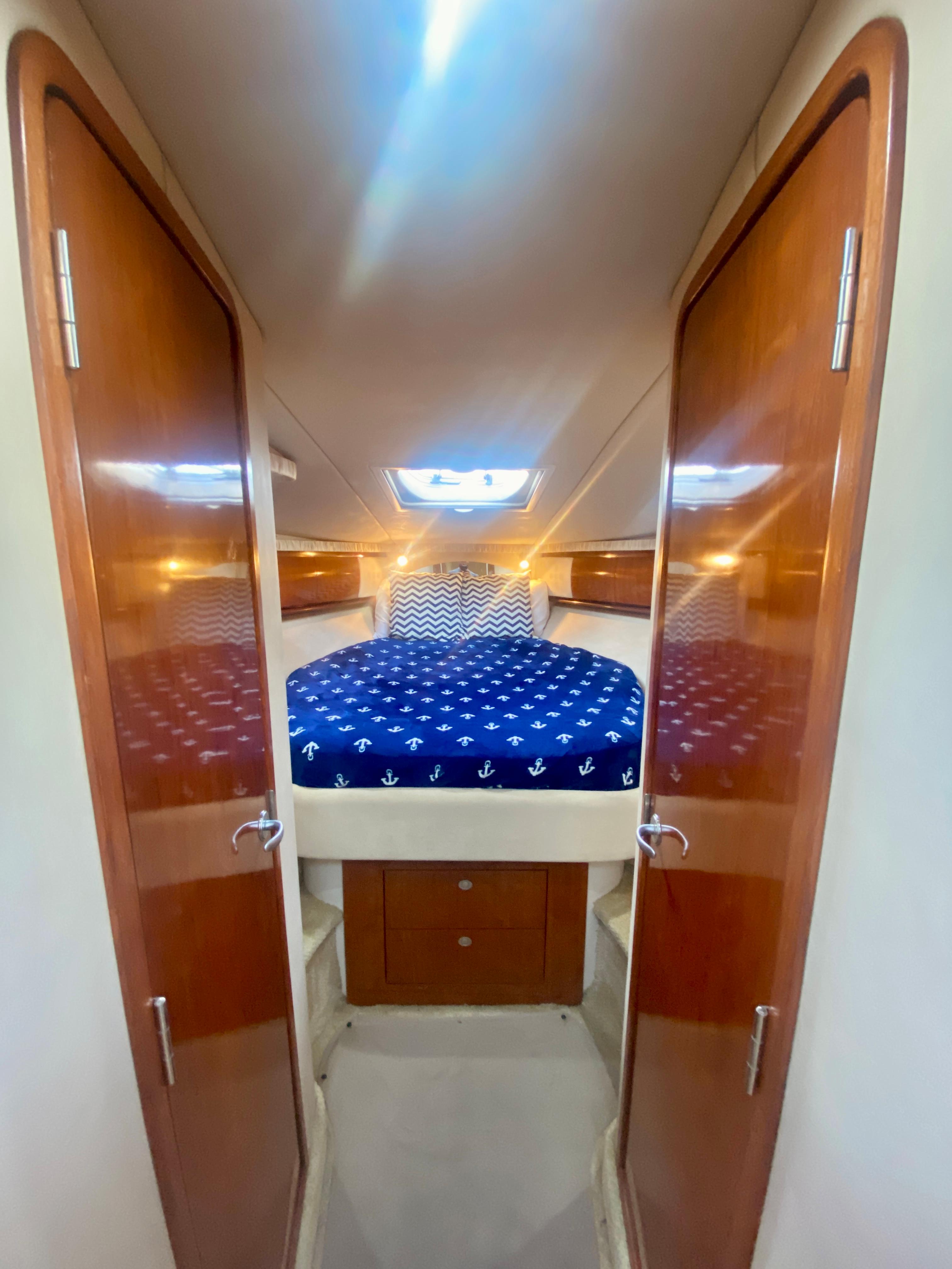 2005 Sea Ray 420 Sundancer cabin with double bed and wooden doors.