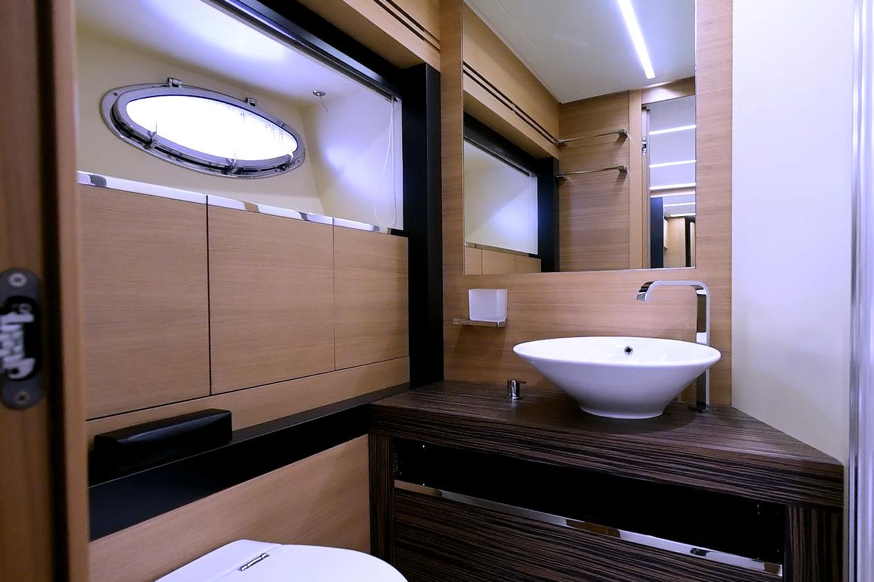 Luxurious bathroom interior of 2015 Pershing 92 yacht with modern sink and wooden accents.