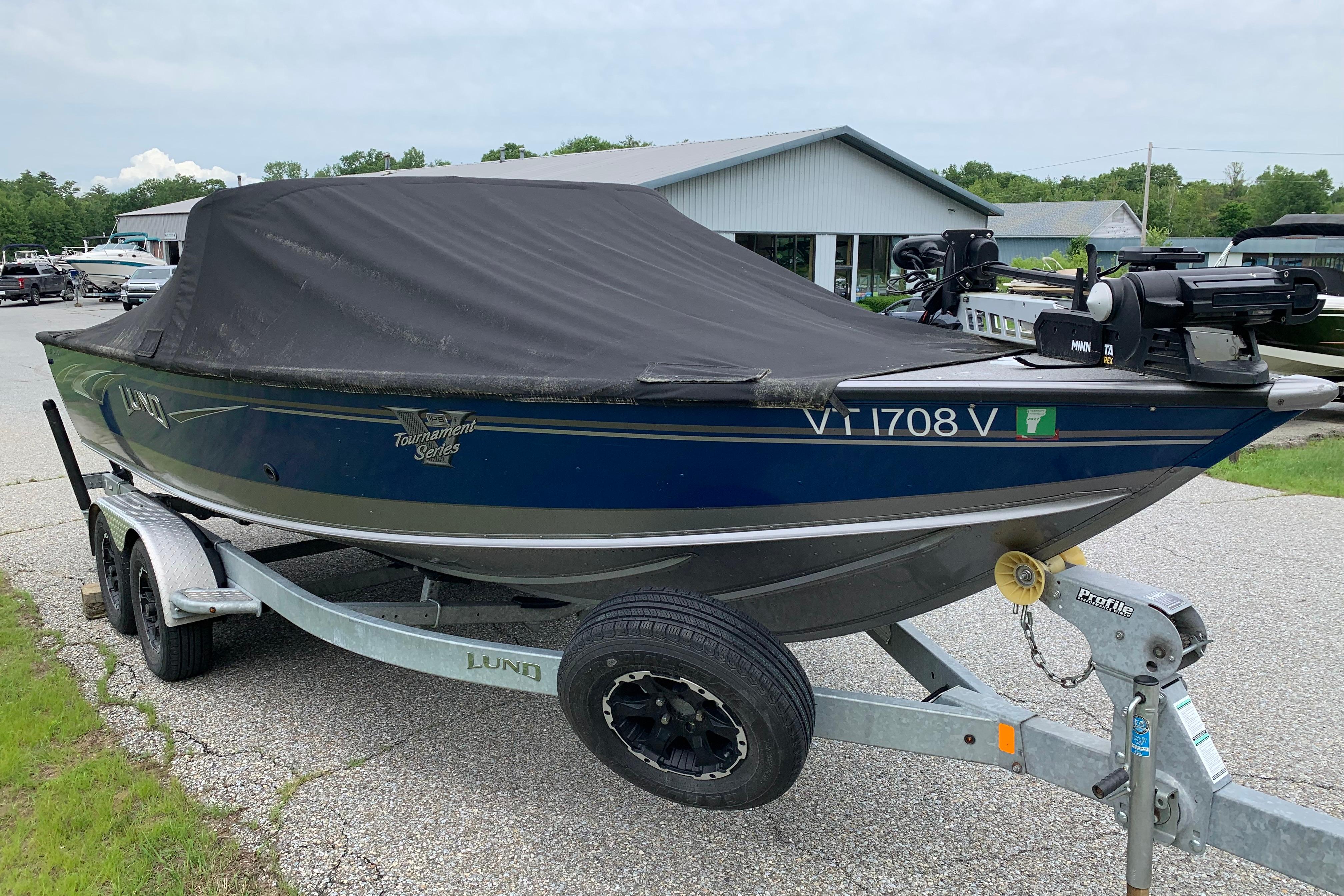 2019 Lund 2175 Pro-V boat on trailer, covered, parked outdoors.