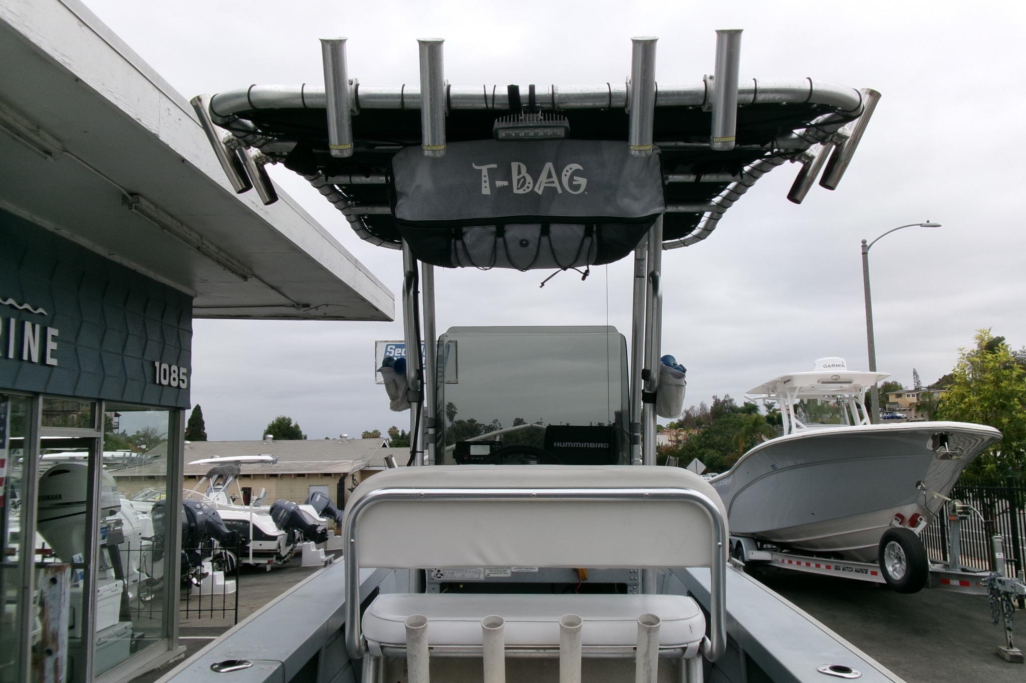 2017 Klamath Bayrunner 19 Baja boat with T-top and rod holders, parked at a marina.