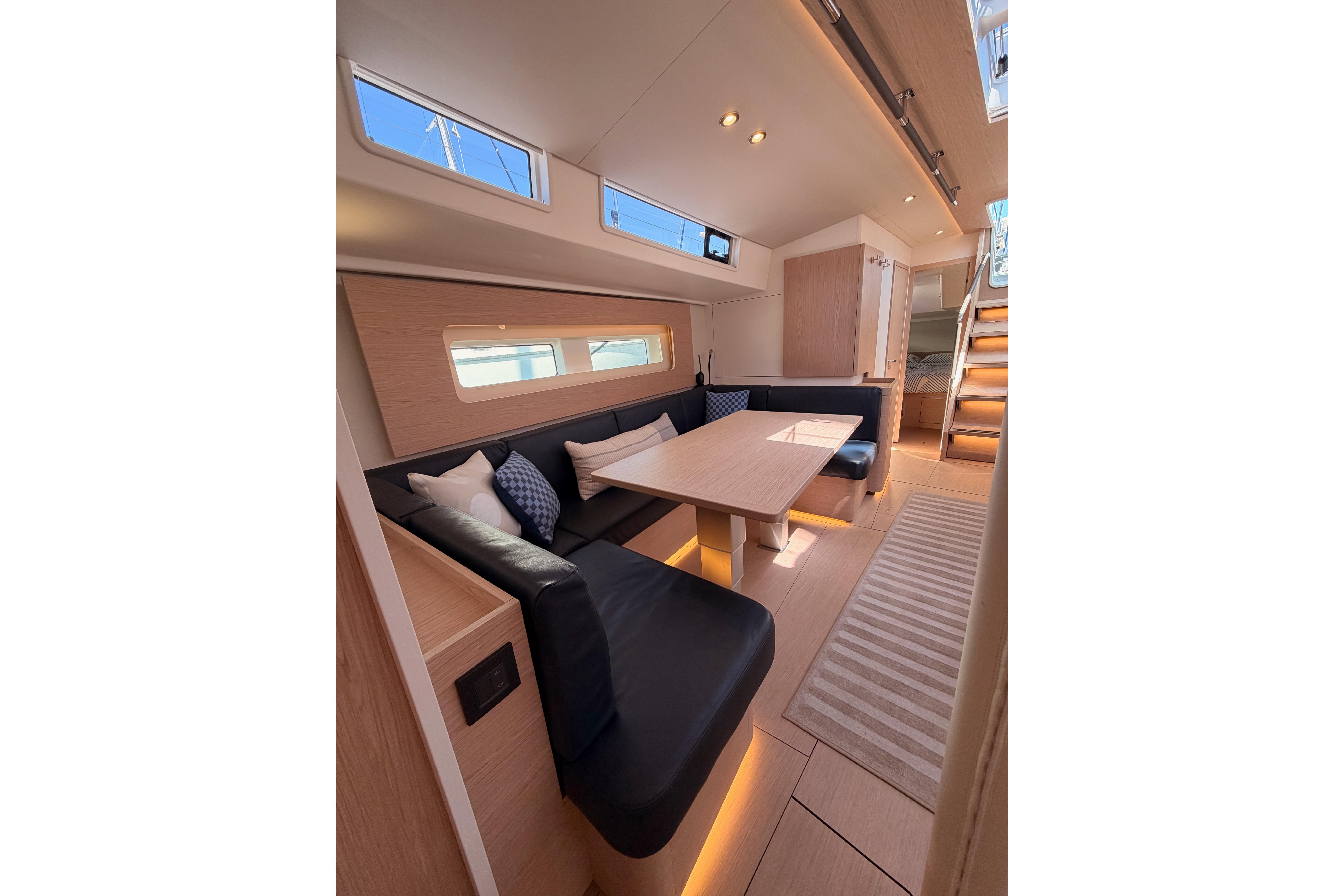 Luxurious interior of 2022 Beneteau Oceanis Yacht 54 with modern seating and elegant lighting.