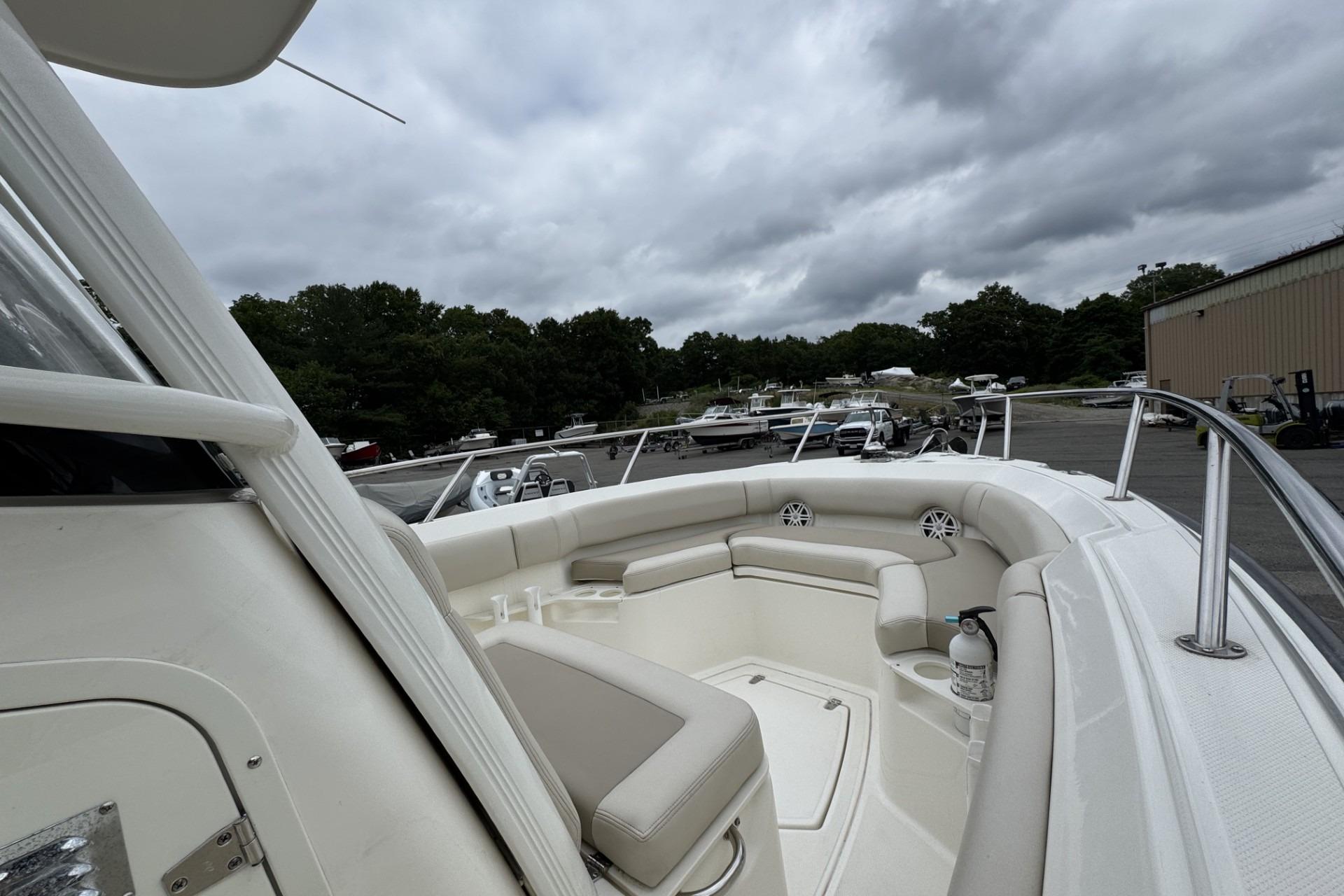 2024 Boston Whaler 230 Outrage boat with spacious seating, docked under cloudy skies.