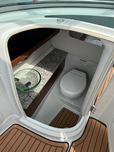 2025 Crownline 290 SS boat bathroom with modern fixtures and wood flooring.