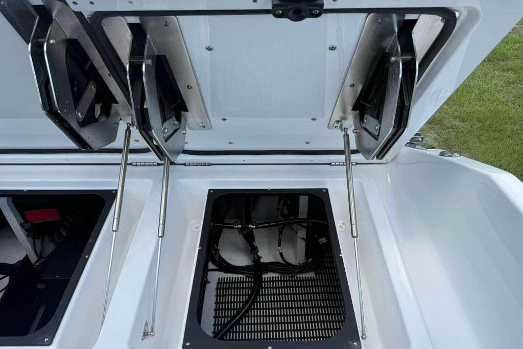 Open storage compartments on a 2026 Monterey Elite 30 OB boat, showcasing interior details.