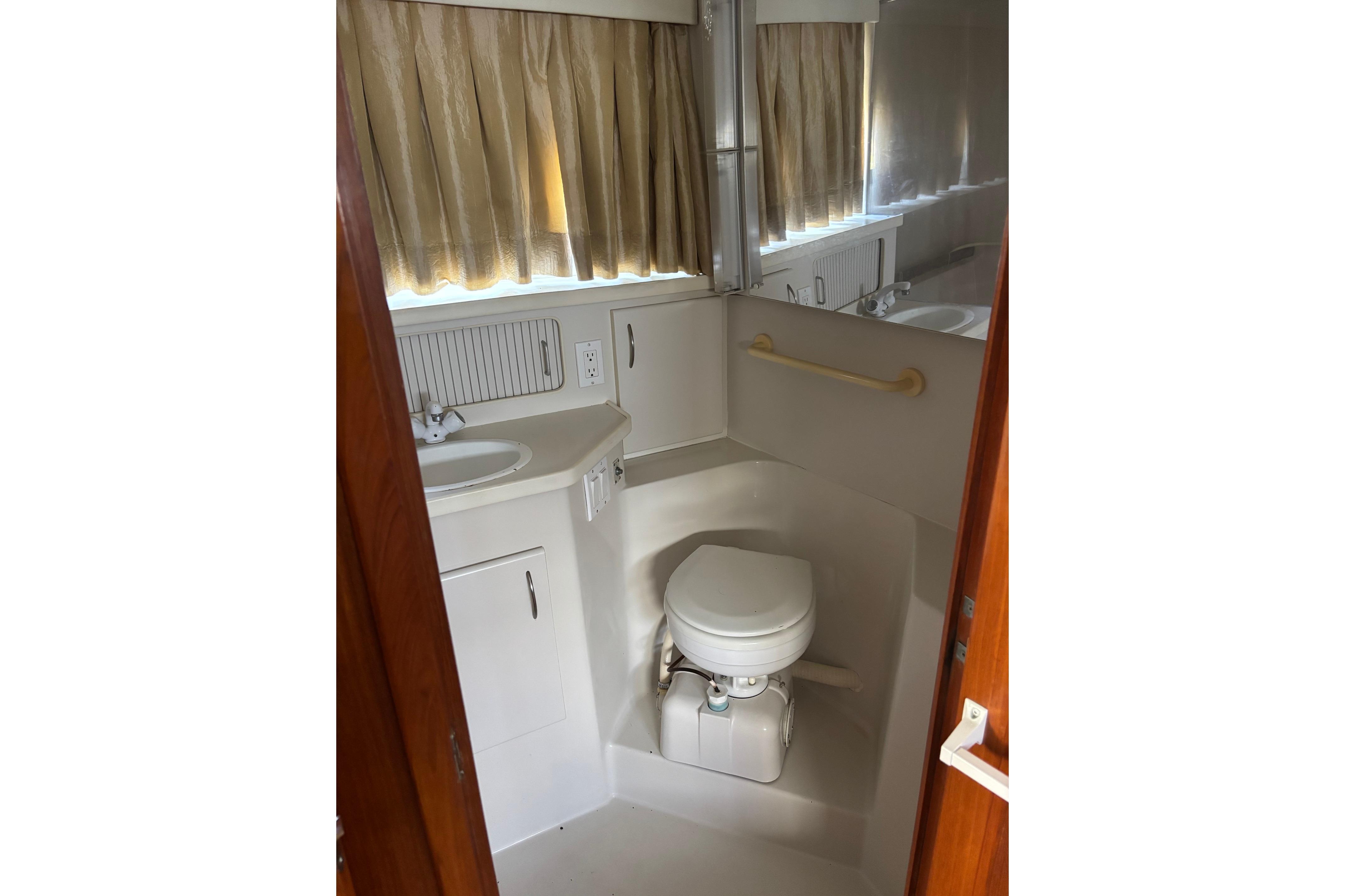 Bathroom interior of 1995 Carver 356 Aft Cabin Motor Yacht with sink and toilet.