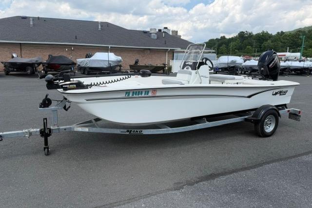 2025 Mako Pro Skiff 17 CC boat on trailer, parked outdoors under cloudy sky.