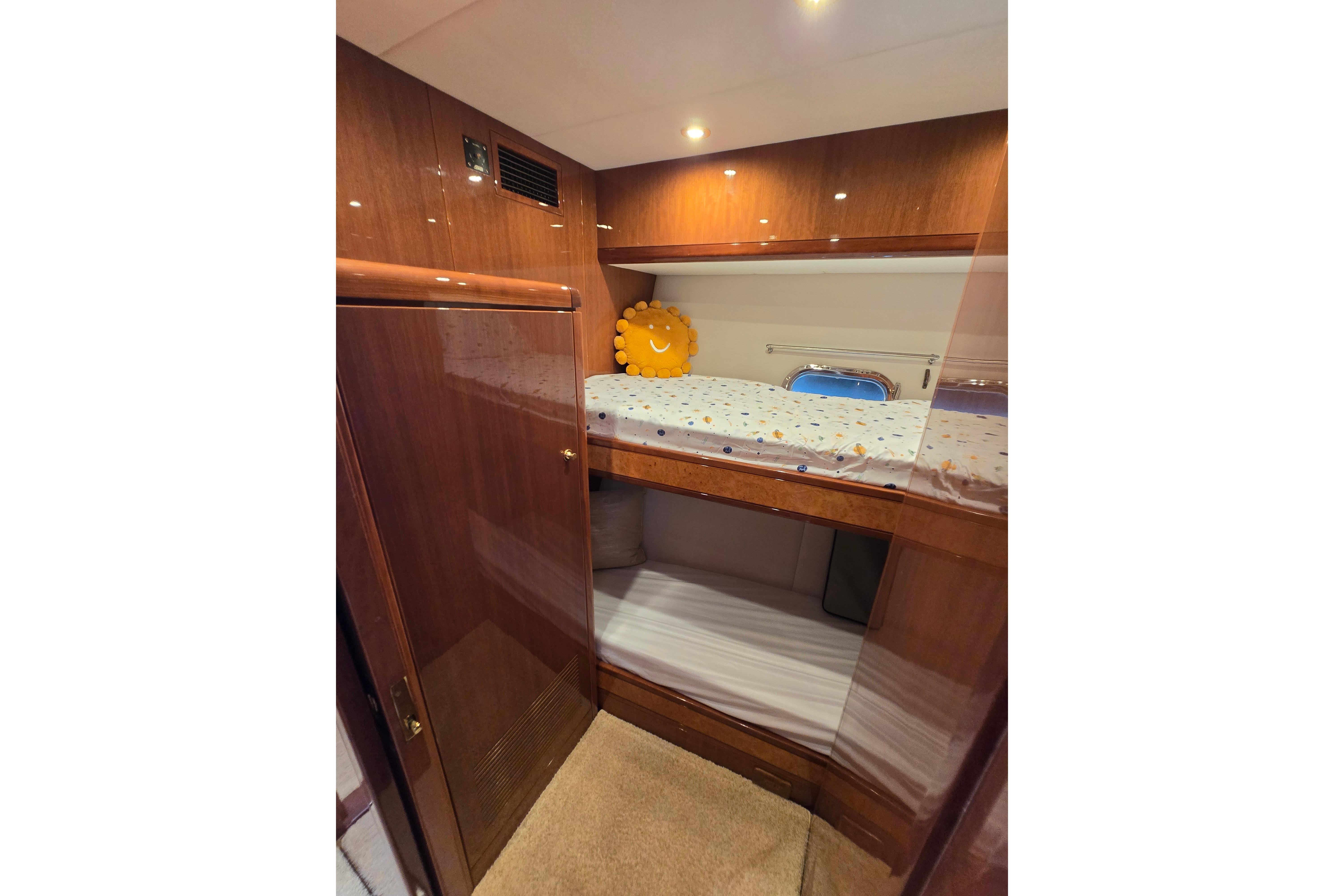 Luxurious 2004 Grand Harbour 58 yacht cabin with wooden finish and cozy bunk beds.