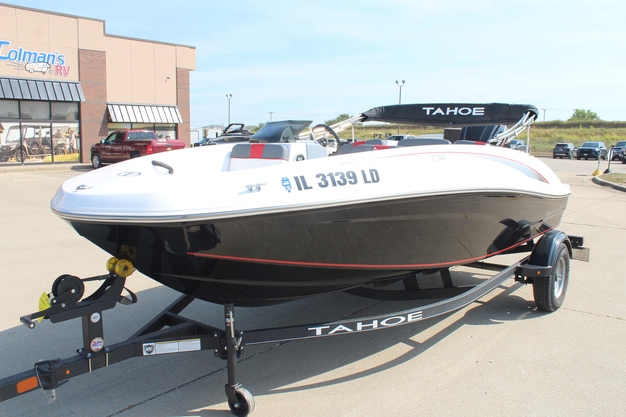 2023 Tahoe T16 boat on trailer outside dealership, featuring sleek black and white design.