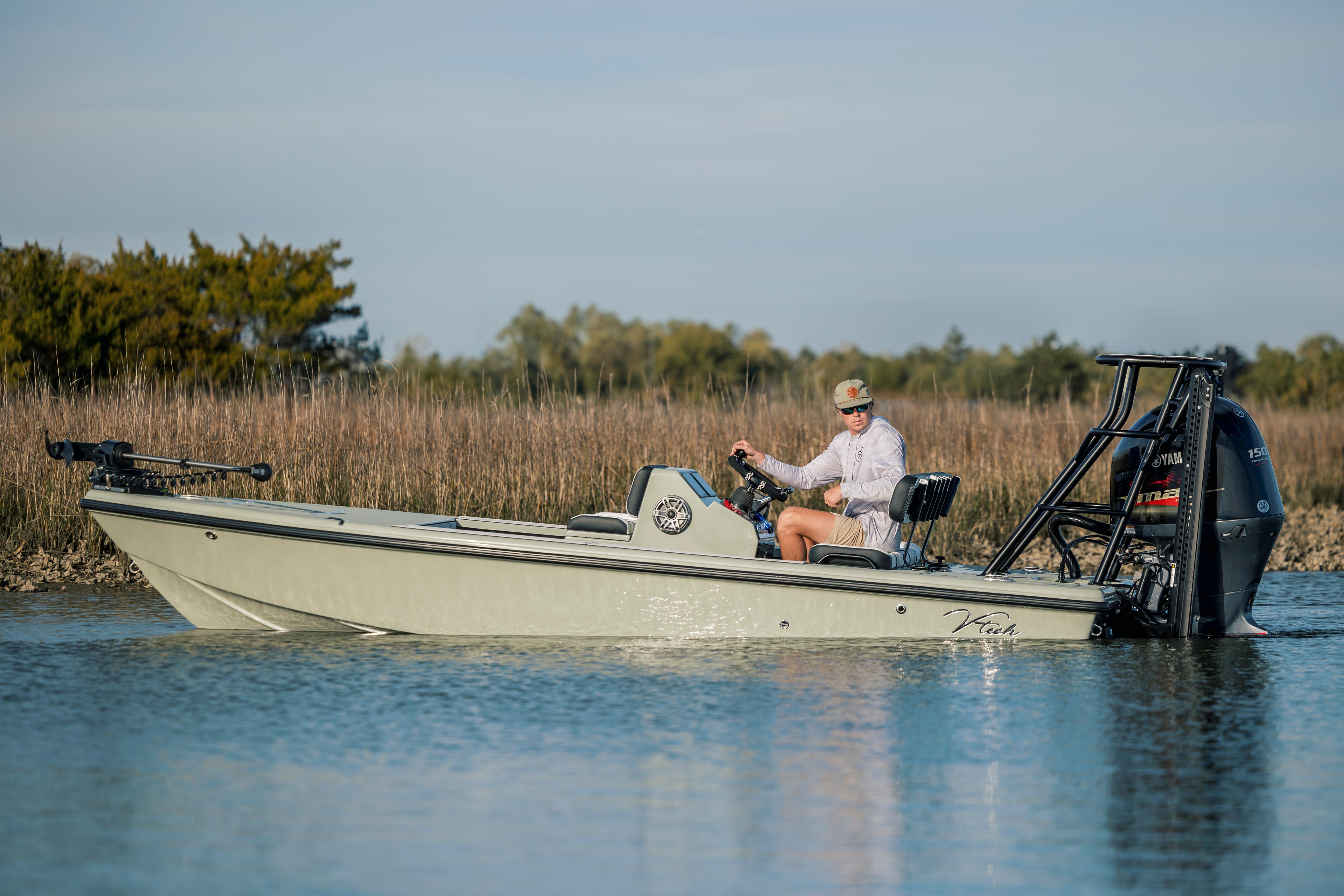 A person operates a 2025 Vtech 18 boat on a calm waterway.