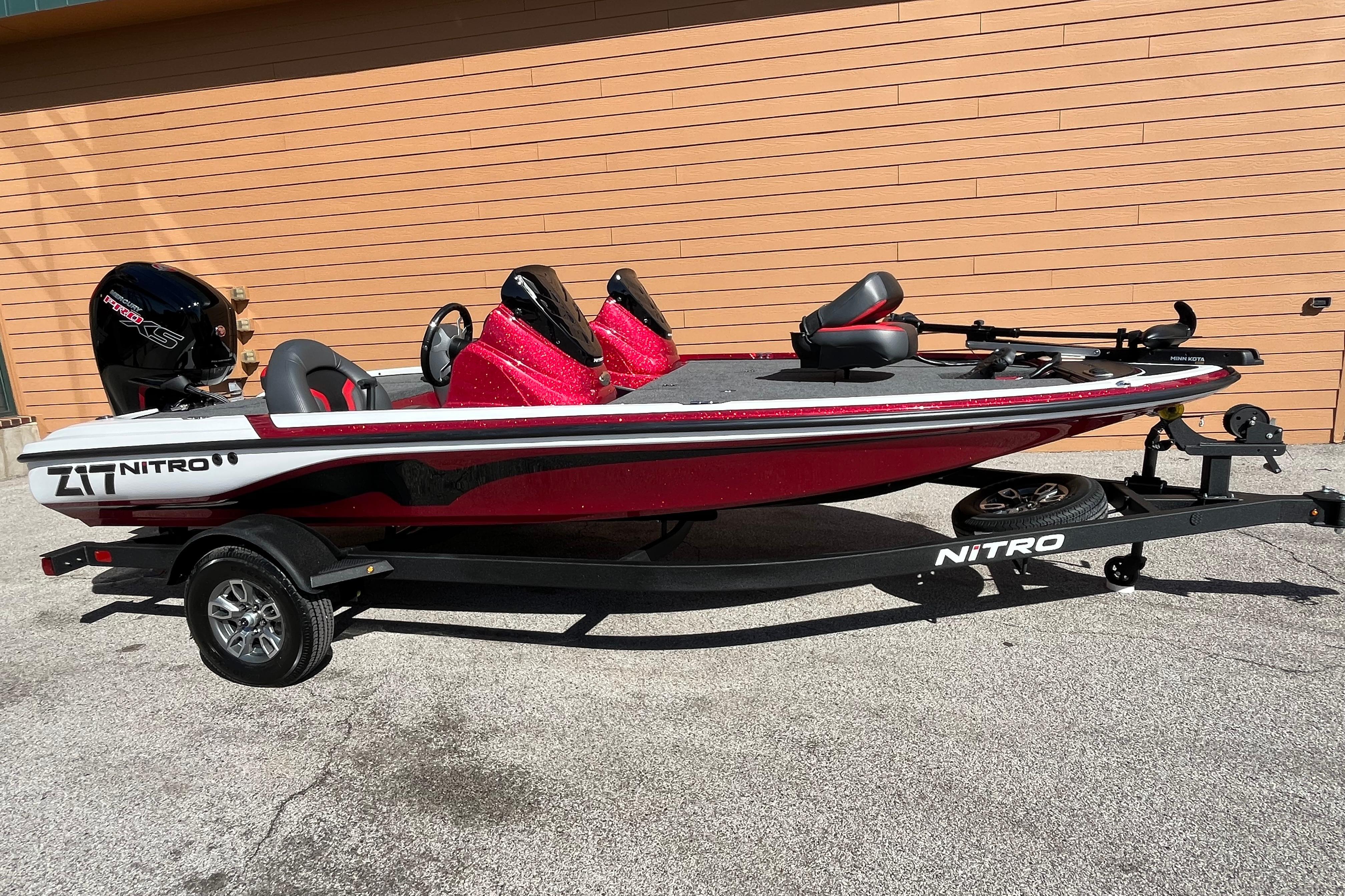 2026 Nitro Z17 boat with red and black design on a trailer, parked outdoors.
