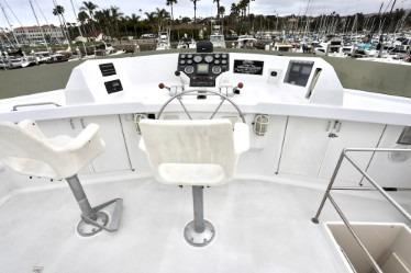 Helm of 1989 custom boat with dual seats and marina view.