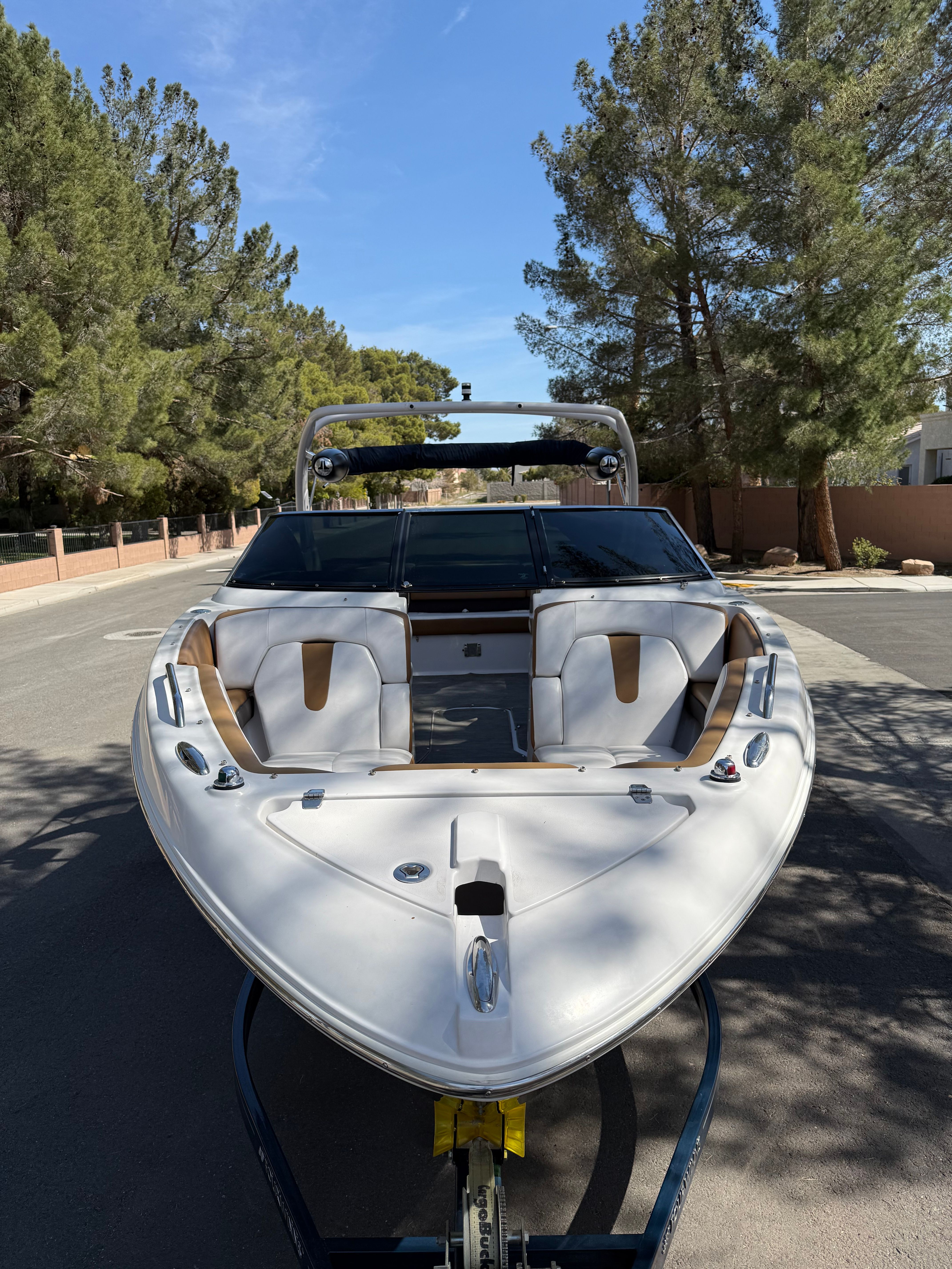 2019 Four Winns H260 boat on trailer, surrounded by trees.