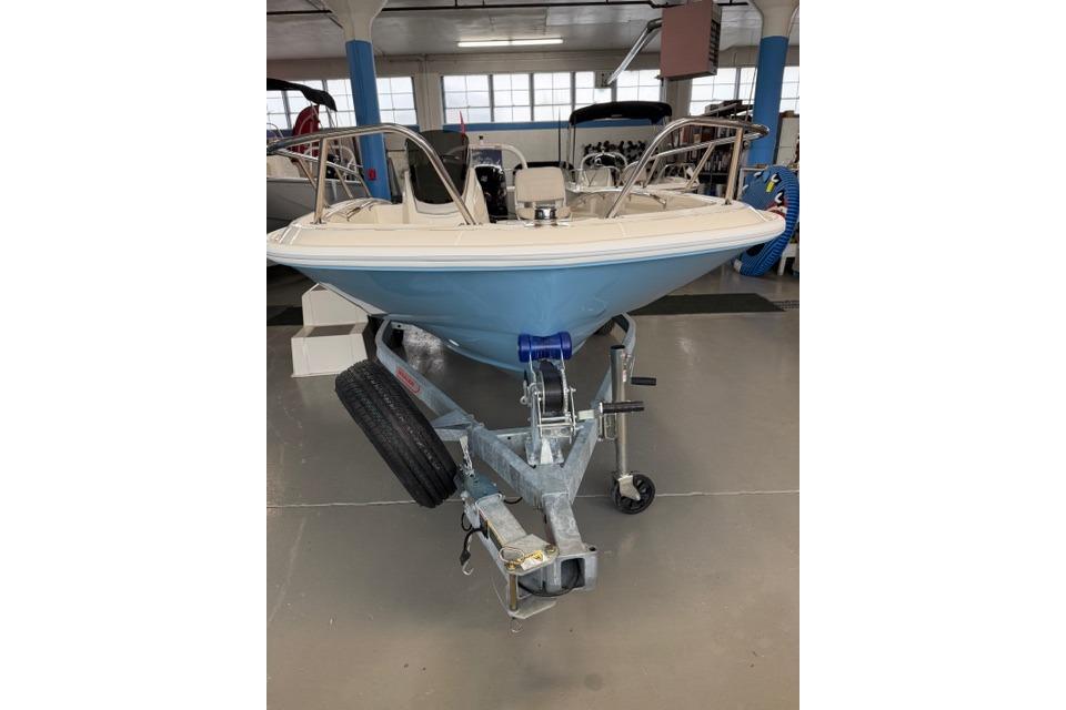 2026 Boston Whaler 160 Super Sport boat on trailer in showroom.