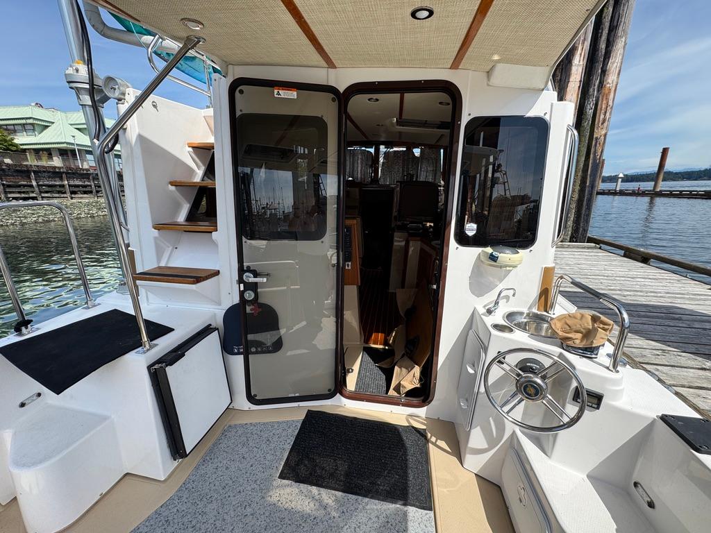 2019 Ranger Tugs R-31 CB boat interior with open door and dock view.
