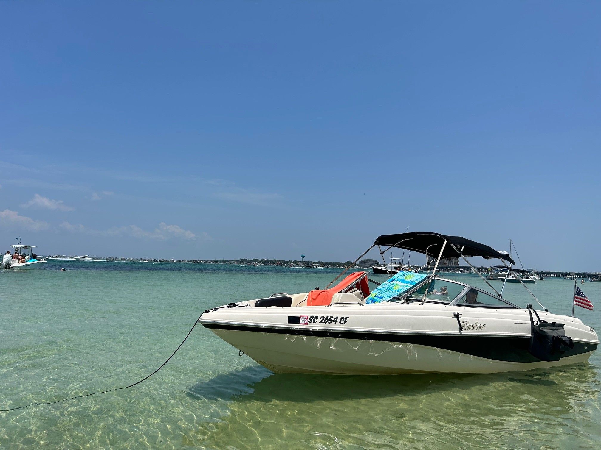 2002 Rinker 212 Captiva Bowrider anchored in clear water.