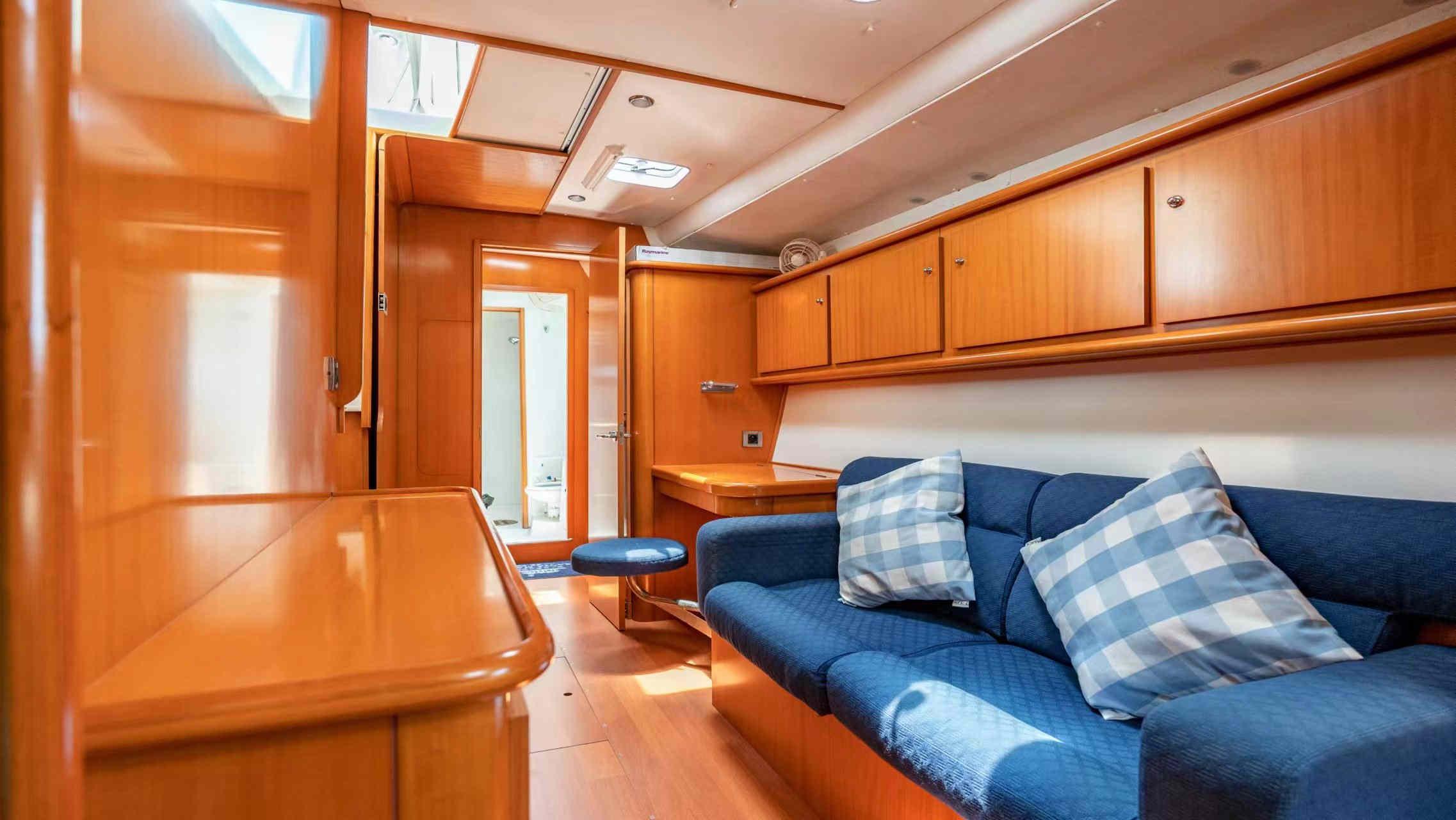Interior of 2007 Lagoon 440 yacht with wooden cabinetry and blue seating.