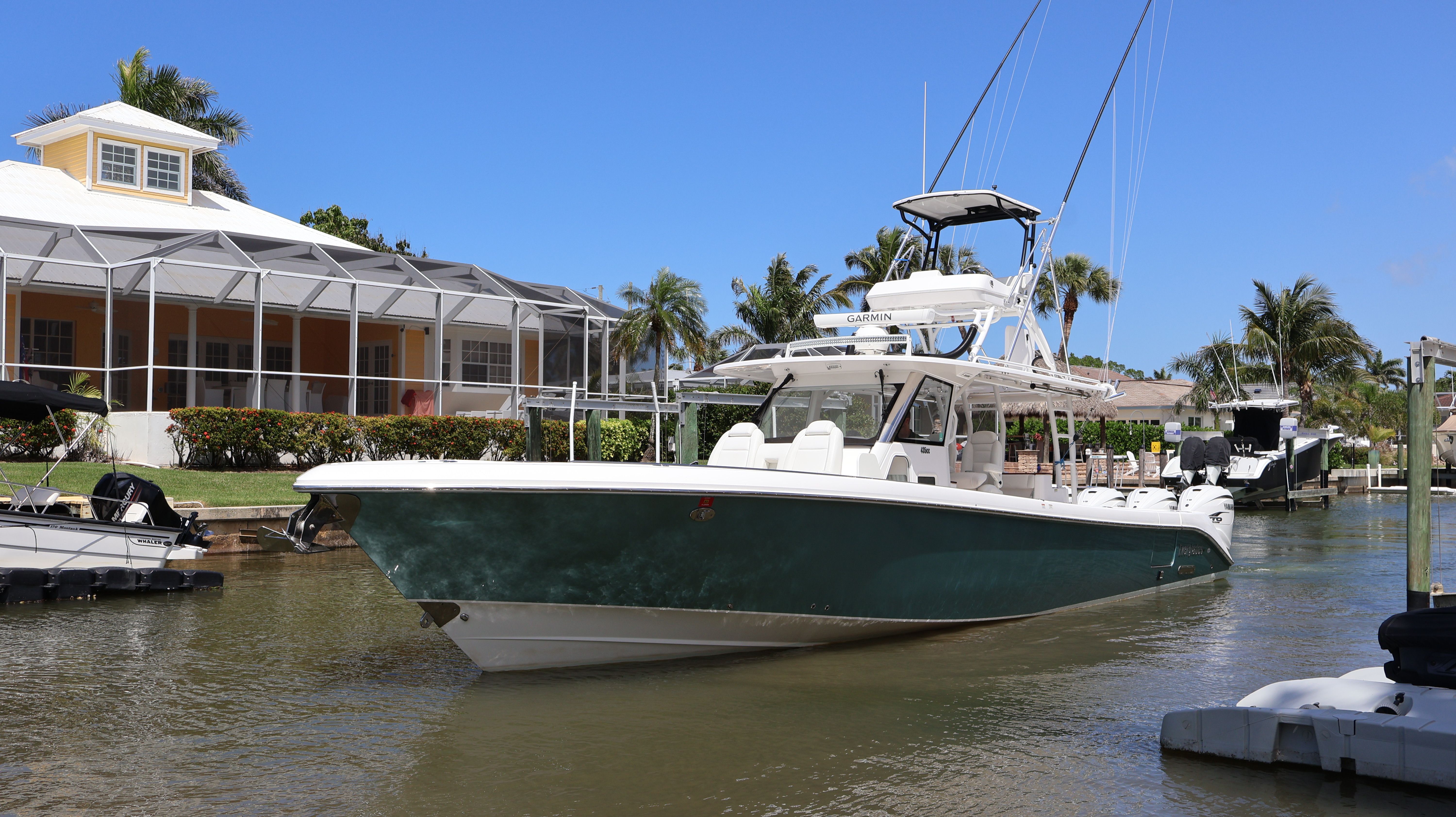 2019 Everglades 435 Center Console boat on water near a house.