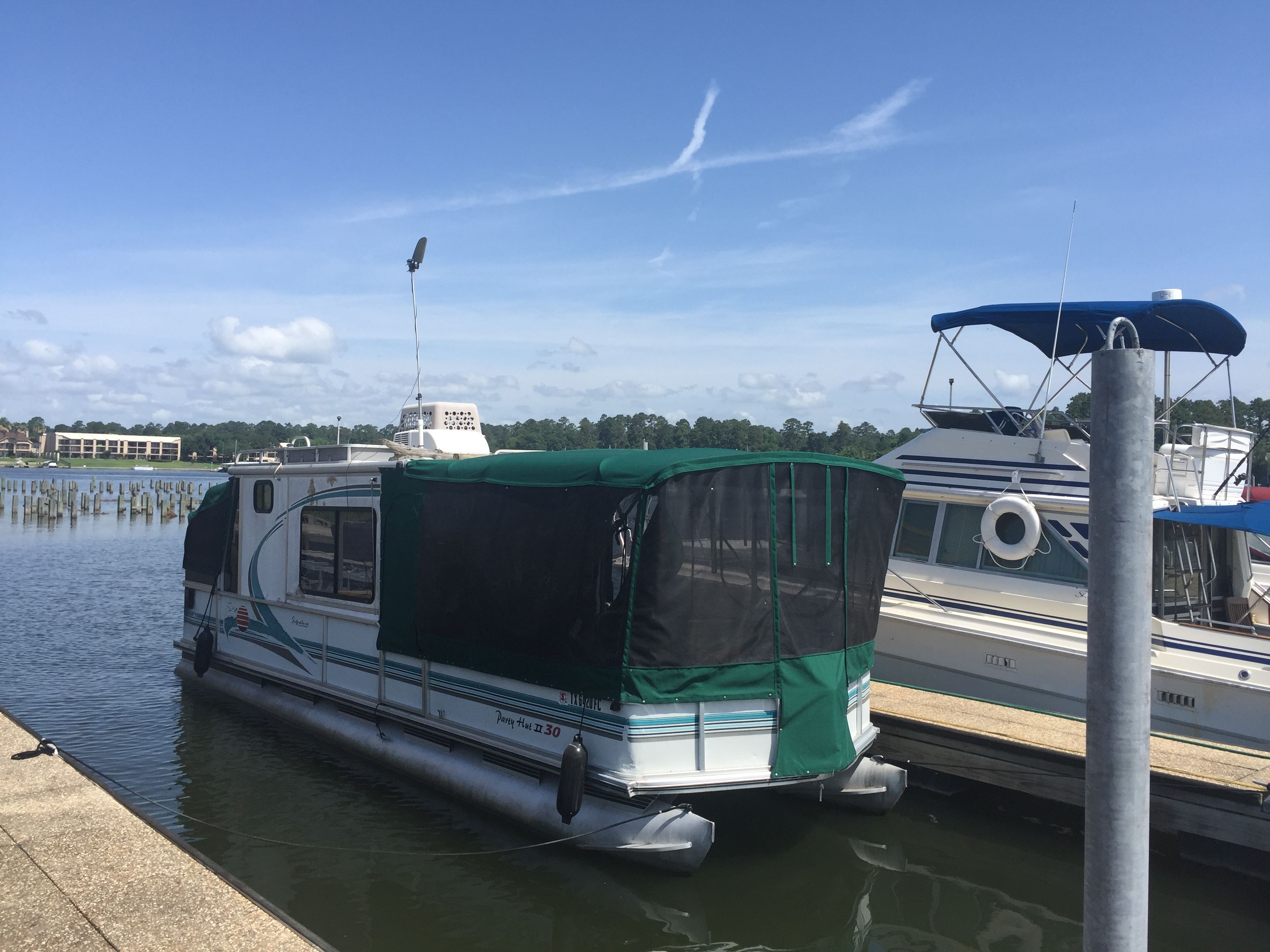 A party boat with a green canopy docked at the pier.