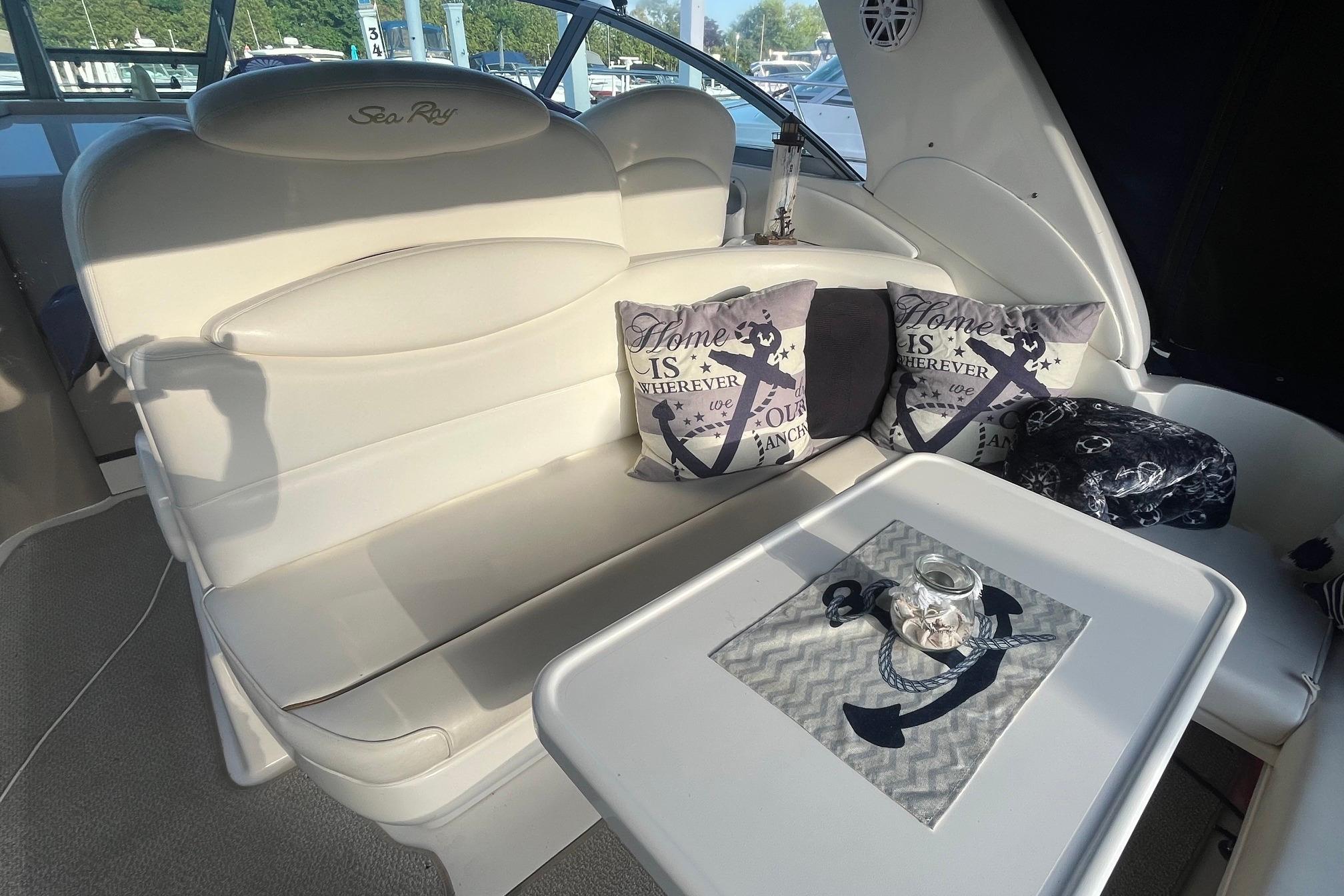 Interior of 2001 Sea Ray 340 Sundancer with cushioned seating and nautical-themed decor.