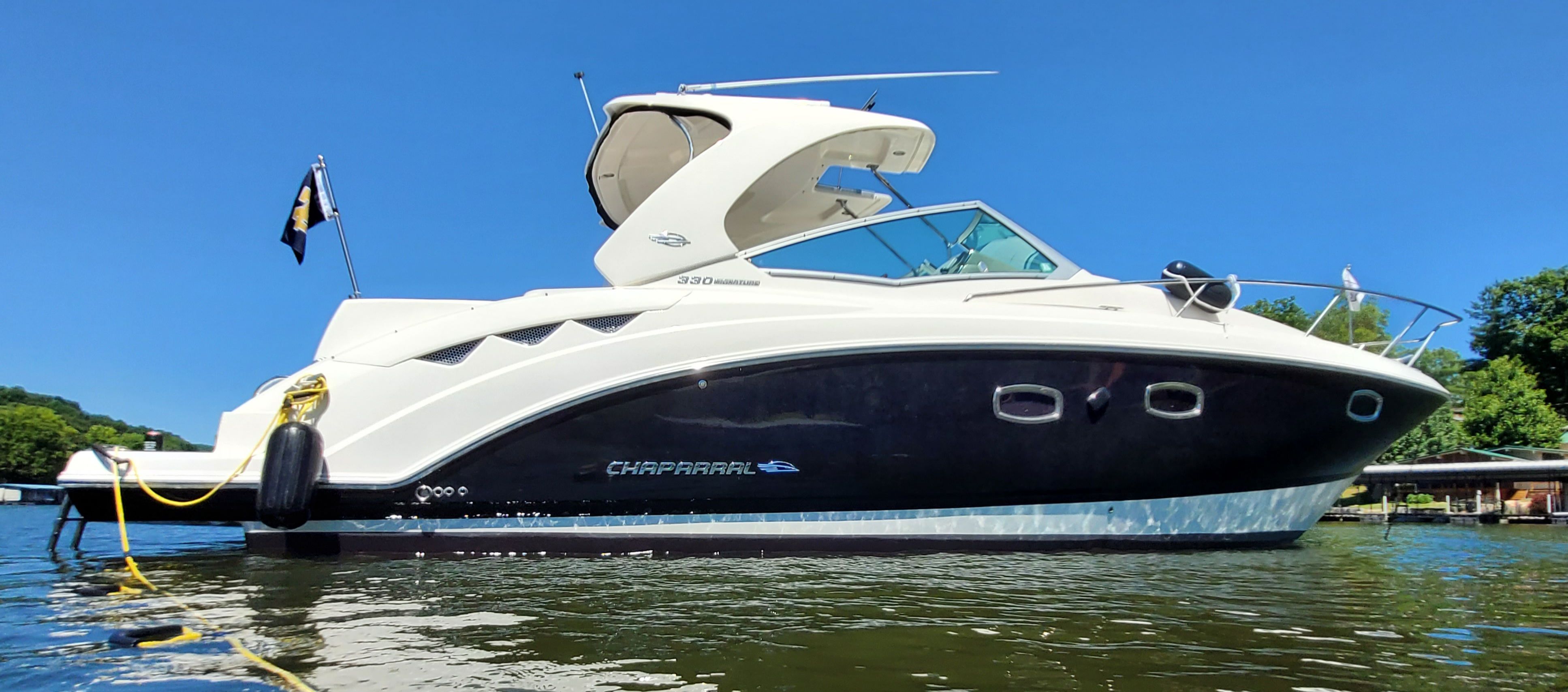 2014 Chaparral 330 Signature boat on calm water.