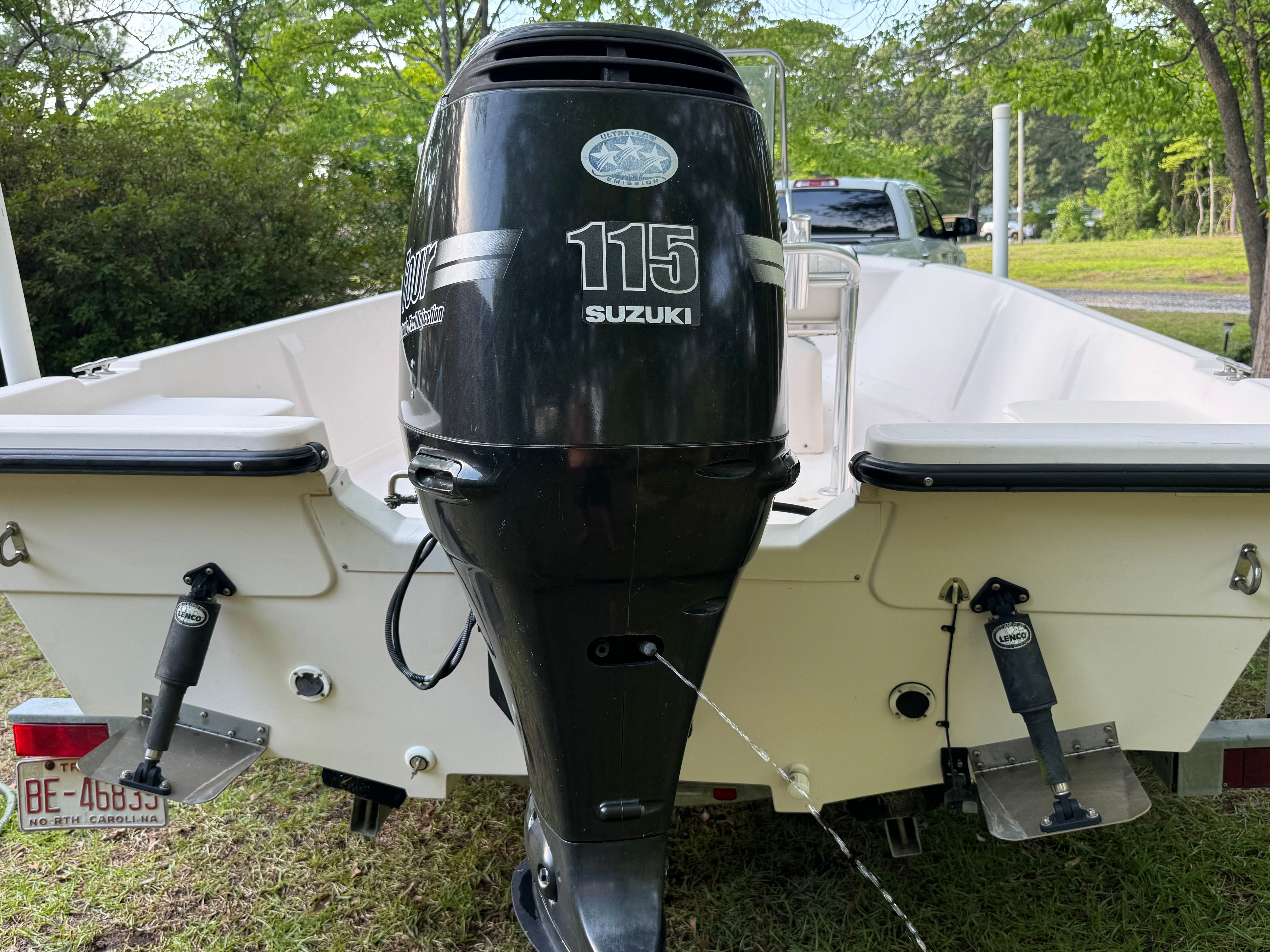 The image shows the stern of a white boat with a Suzuki 115 outboard motor.