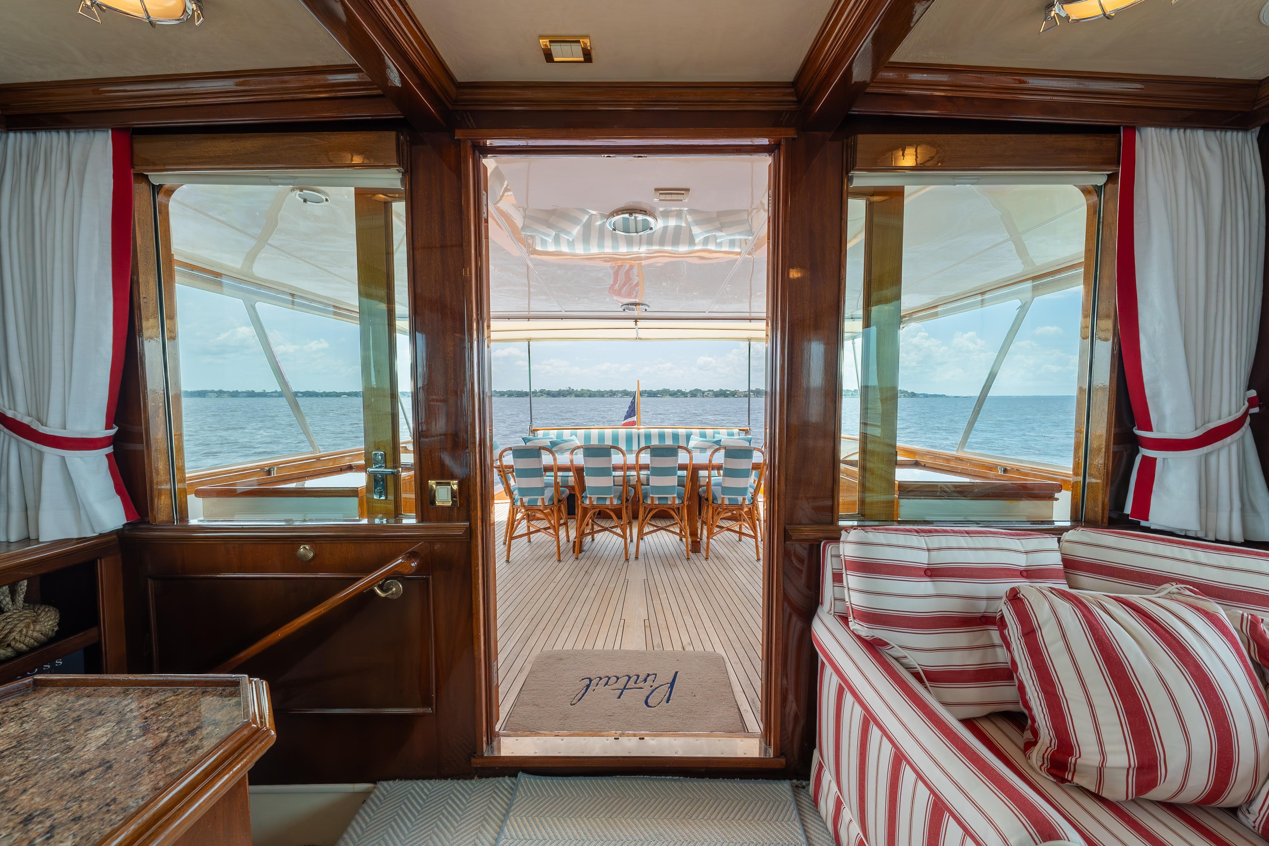 Luxurious 1963 Trumpy Classic yacht interior with striped seating and ocean view.