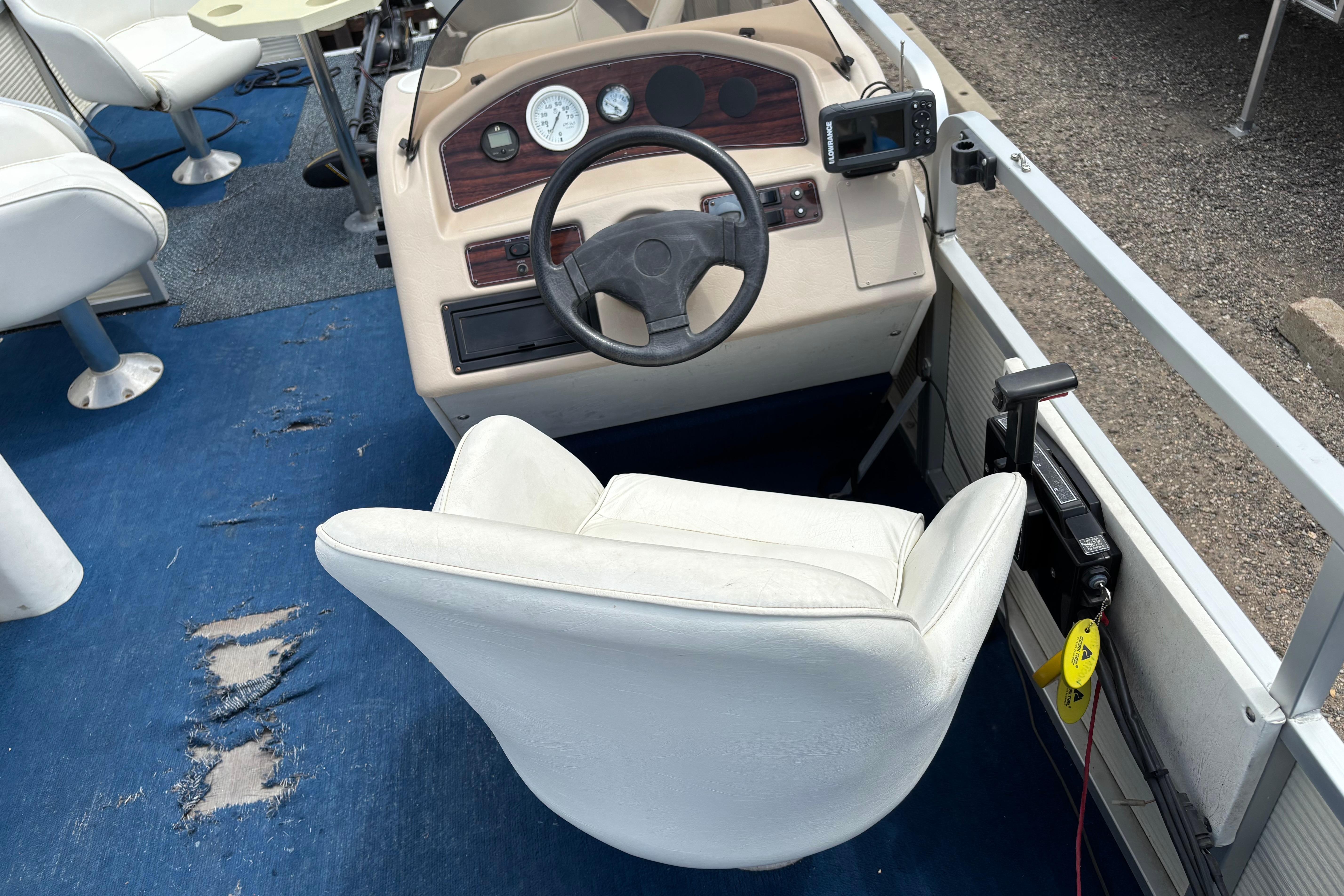 1997 Northwood 24' Pontoon boat interior with steering wheel and white captain's chair.