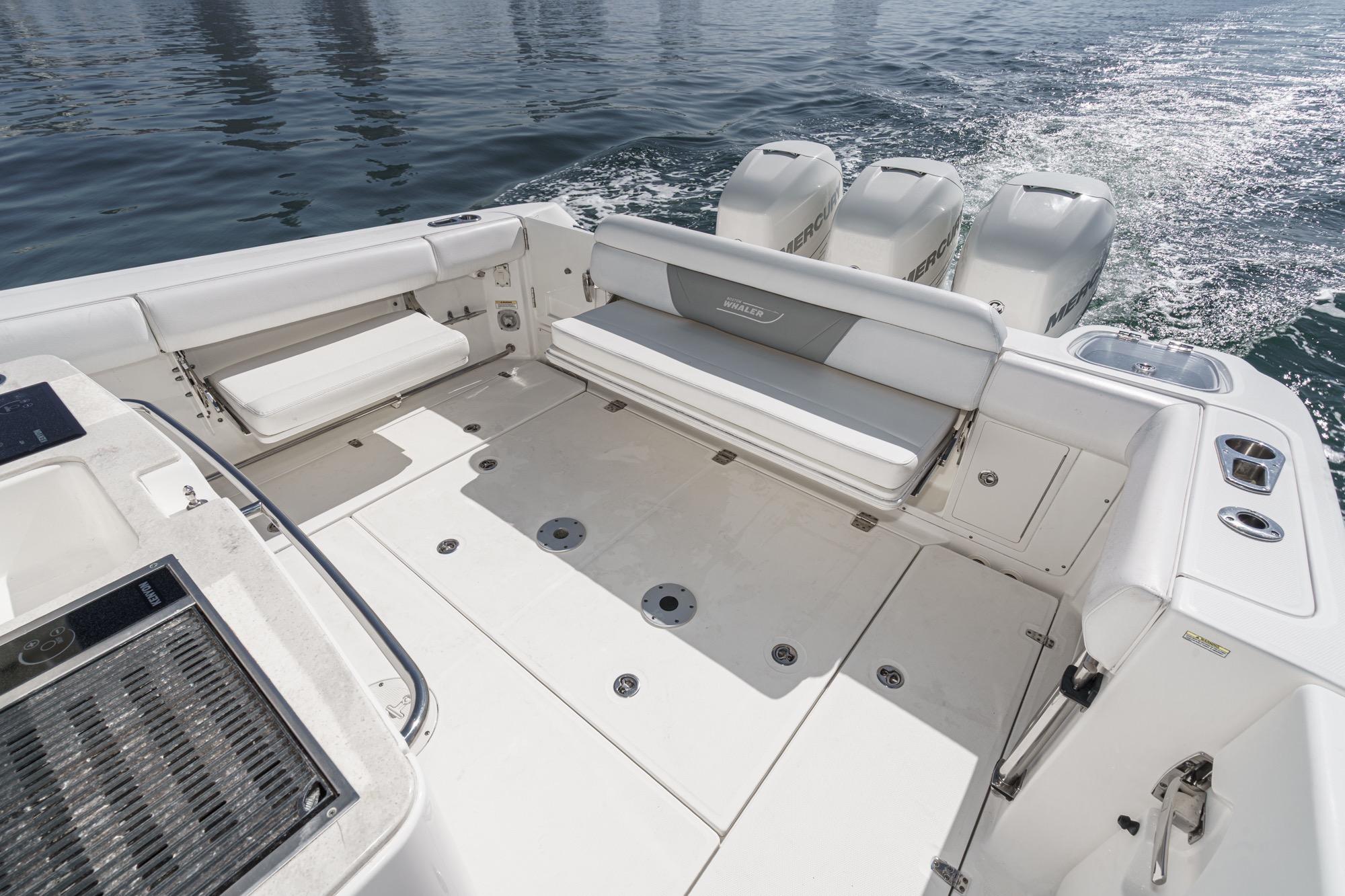 2015 Boston Whaler 370 Outrage boat deck with seating and triple Mercury engines.