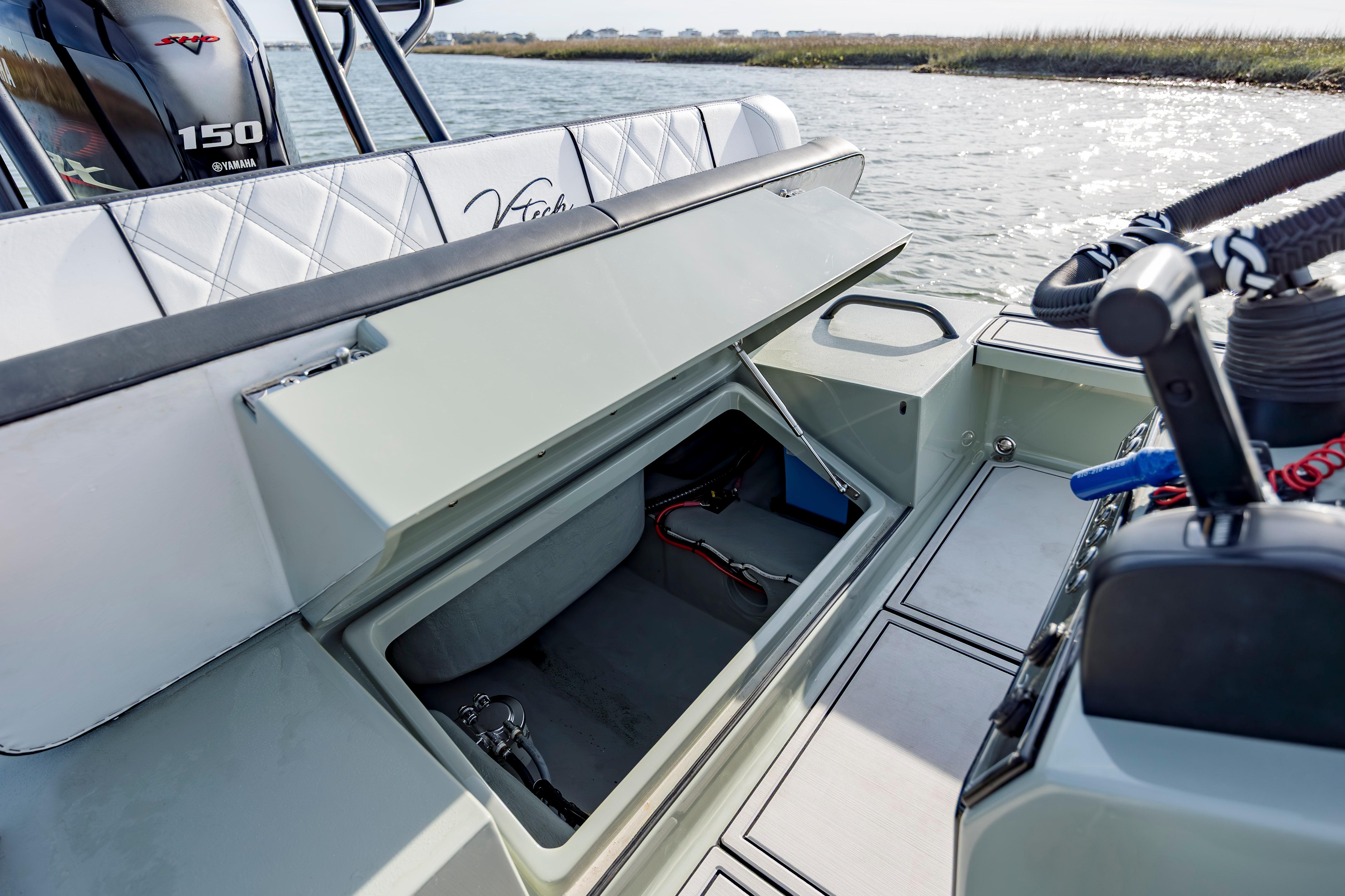 Open storage compartment on a 2025 Vtech 18 boat, near water.