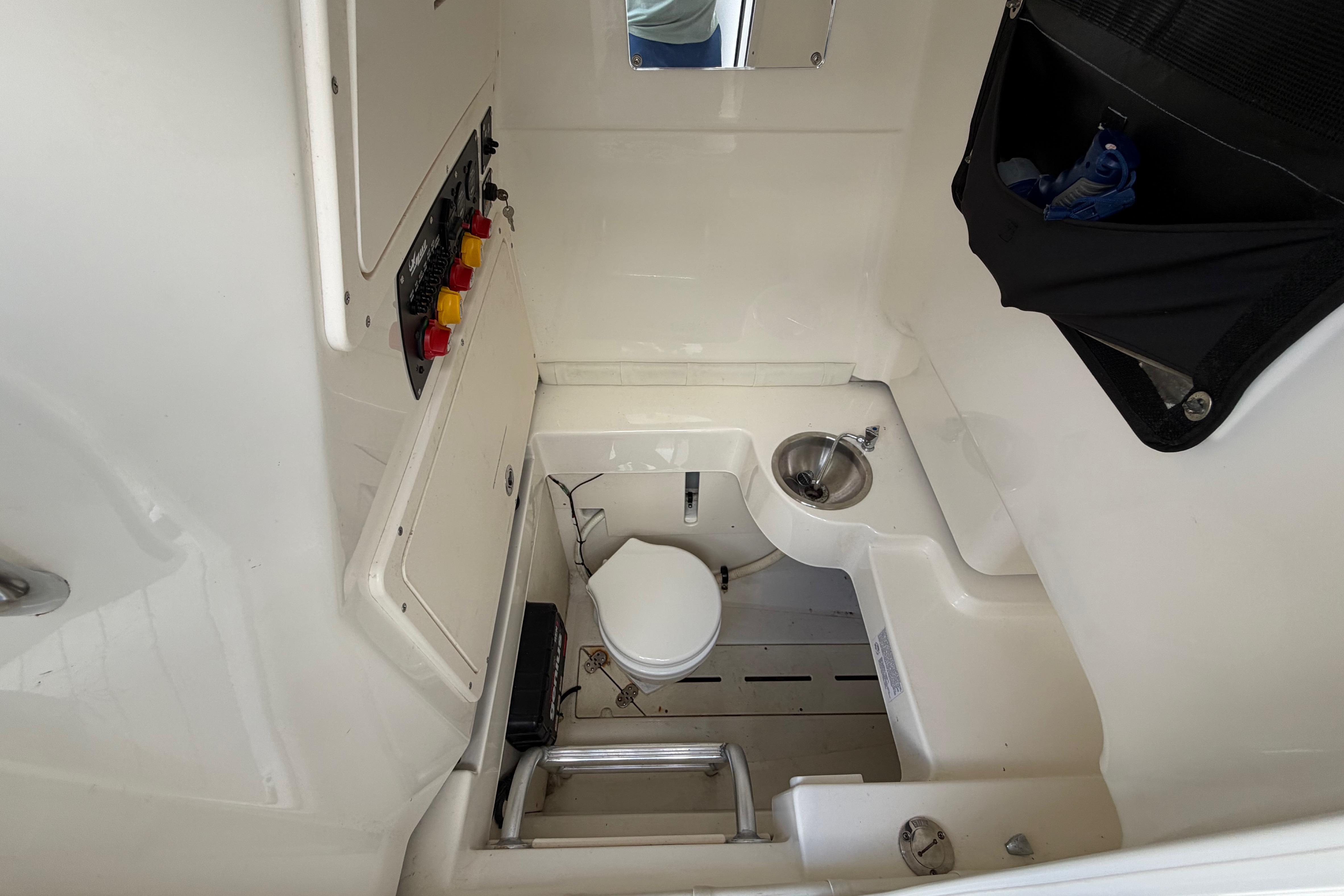 Interior of 2017 Mako 284 Center Console boat with toilet and sink.