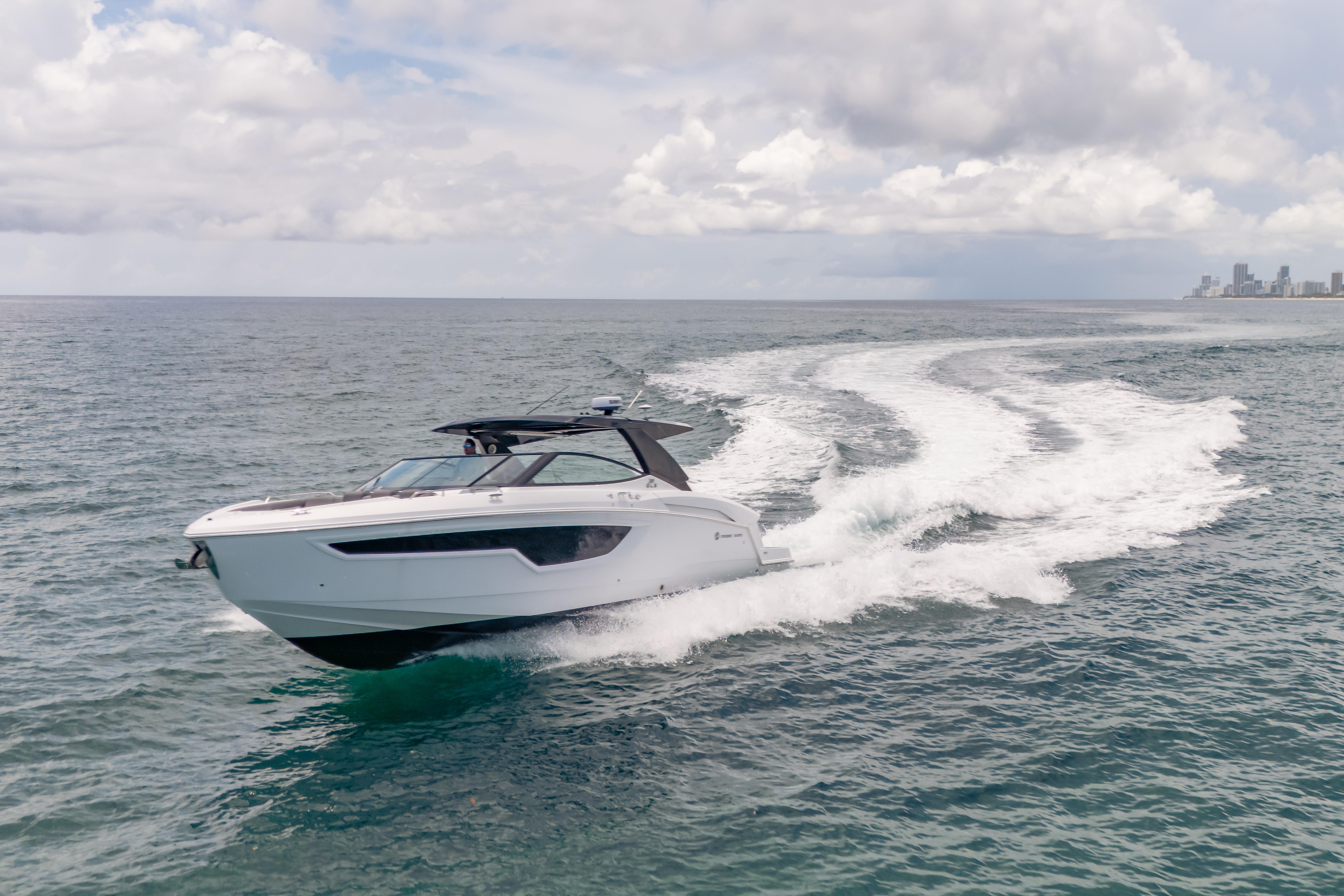 2021 Cruisers Yachts 38 GLS speeding on open water under cloudy skies.